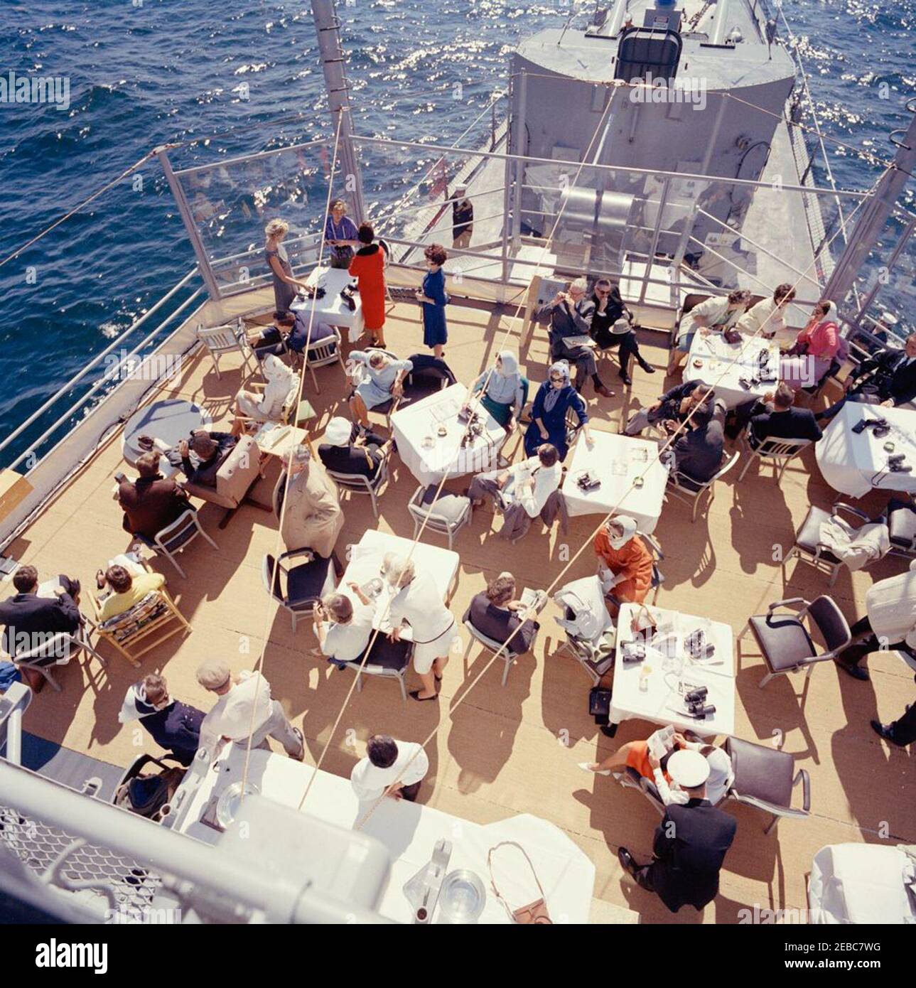 Il presidente Kennedy si accuda alla prima gara di Coppa Americau0027s. Il presidente John F. Kennedy e la First Lady Jacqueline Kennedy partecipano alla prima gara della Americau0027s Cup 1962 a bordo della USS Joseph P. Kennedy, Jr., al largo della costa di Newport, Rhode Island. Il presidente Kennedy (seduto a sinistra, guardando attraverso il binocolo) guarda la corsa; la signora Kennedy (in basso a sinistra) visita con il capo del protocollo, Angier Biddle Duke. Anche nella foto: John Forbes Kerry; Janet Jennings Auchincloss; Franklin D. Roosevelt, Jr.; Nuala Pell, moglie del senatore Claiborne Pell (Rhode Island); Julia Ann Shepard; Senatore John Sherman Co Foto Stock