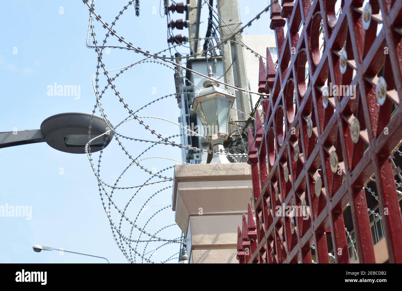 il filo spinato si arrotola sulla parete e sulla porta d'ingresso per proteggersi In Thailandia Foto Stock