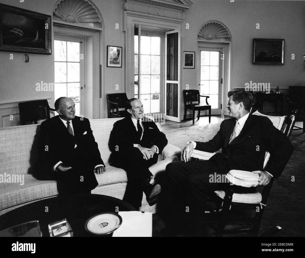Incontro con Sir Garfield Barwick, Ministro degli Affari Esteri dell'Australia, 11:37. Il presidente John F. Kennedy (in sedia a dondolo) incontra i diplomatici australiani. (L-R) Howard Beale, Ambasciatore negli Stati Uniti dall'Australia; Garfield Barwick, Ministro degli Affari Esteri dell'Australia; Presidente Kennedy. Ufficio ovale, Casa Bianca, Washington, D.C. Foto Stock