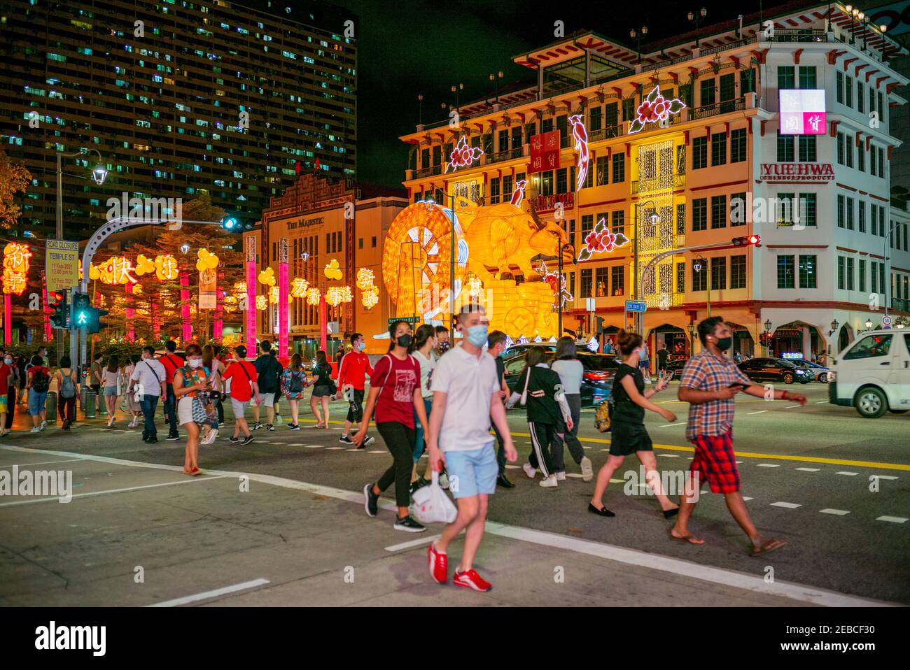 Le persone che indossano maschere facciali camminano davanti ad una decorazione di bue illuminata a Chinatown durante la vigilia del Capodanno lunare. Singapore è entrata nella fase 3 il 28 dicembre 2020, consentendo alle persone in gruppi di 8 di incontrarsi per incontri sociali. Foto Stock Le persone che indossano maschere facciali camminano davanti ad una decorazione di bue illuminata a Chinatown durante la vigilia del Capodanno lunare. Singapore è entrata nella fase 3 il 28 dicembre 2020, consentendo alle persone in gruppi di 8 di incontrarsi per incontri sociali. Foto Stock