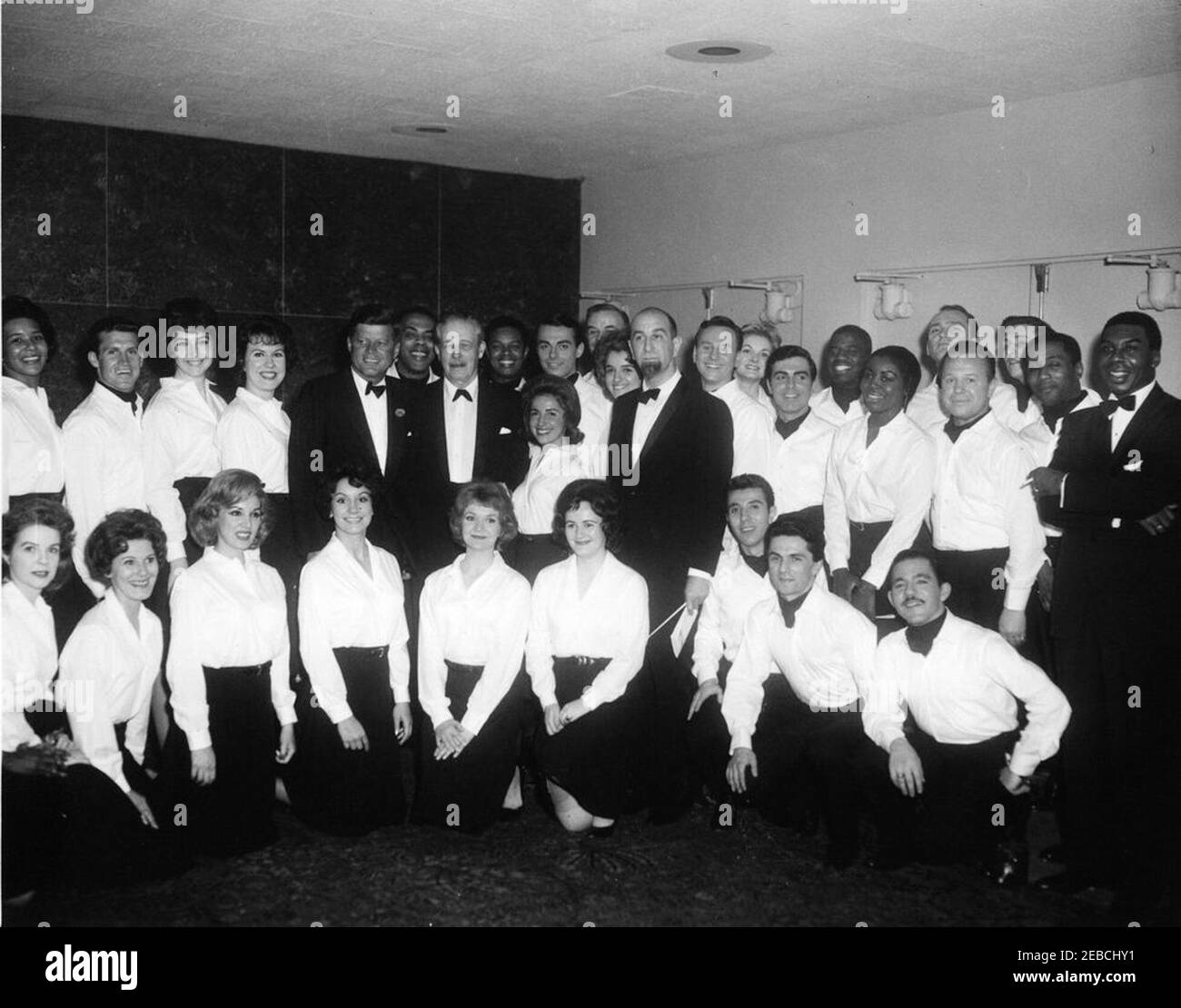 White House Correspellers e News Photographers cena, 19:15. Il presidente John F. Kennedy e il primo ministro Harold Macmillan della Gran Bretagna si levano in piedi con i membri del coro, che hanno suonato alla cena dei Corresidents della Casa Bianca e dei fotografi di notizie. Tra i membri figurano: Issa Annal; Darrell J. Askey; Helen Baisley; Raymond Byrne; Lester Clark, Jr.; Georgia Creighton; al De Sio; Charles Dunn; luce Ennis; Patricia Finch; Jay Gerber; Scott Gibson; Iris Hanisch; Victor R. Helou; Lee Hooper; Lee Howard; Cherry James Shuck; Lawrence; Henry Lruegann; Henry Lerrand; Henry Lerrand; Rosal Foto Stock