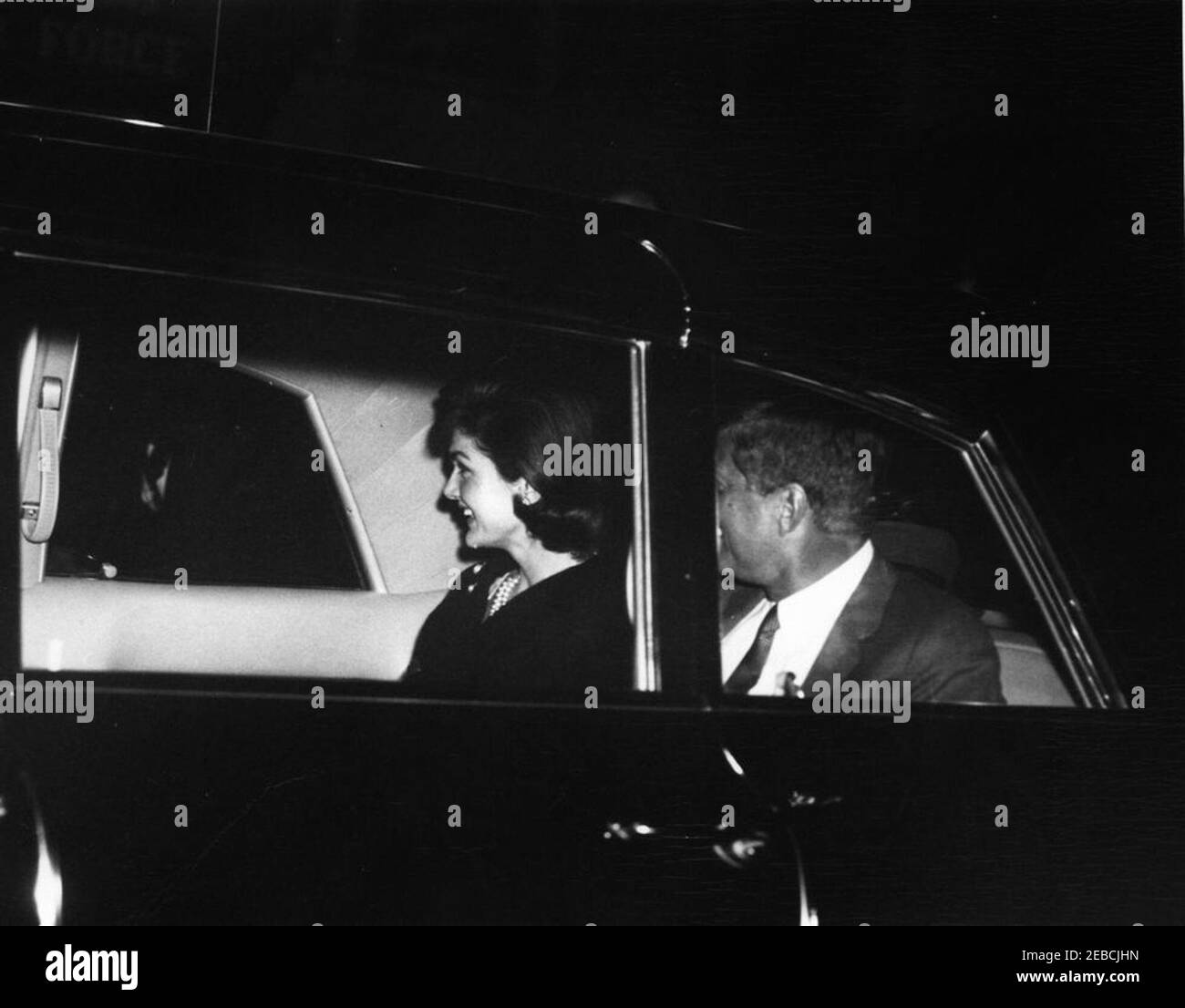 Il presidente Kennedy saluta la First Lady Jacqueline Kennedy (JBK) alla base dell'aeronautica di Andrews al suo ritorno dal suo viaggio in India e Pakistan, alle 19:25. Il presidente John F. Kennedy e la First Lady Jacqueline Kennedy si siedono sul sedile posteriore di un'auto al terminal del Servizio militare di trasporto aereo (MATS), all'aeroporto nazionale di Washington, Washington, D.C. il presidente ha salutato la First Lady all'aeroporto al suo ritorno dal suo viaggio in India e Pakistan. Foto Stock