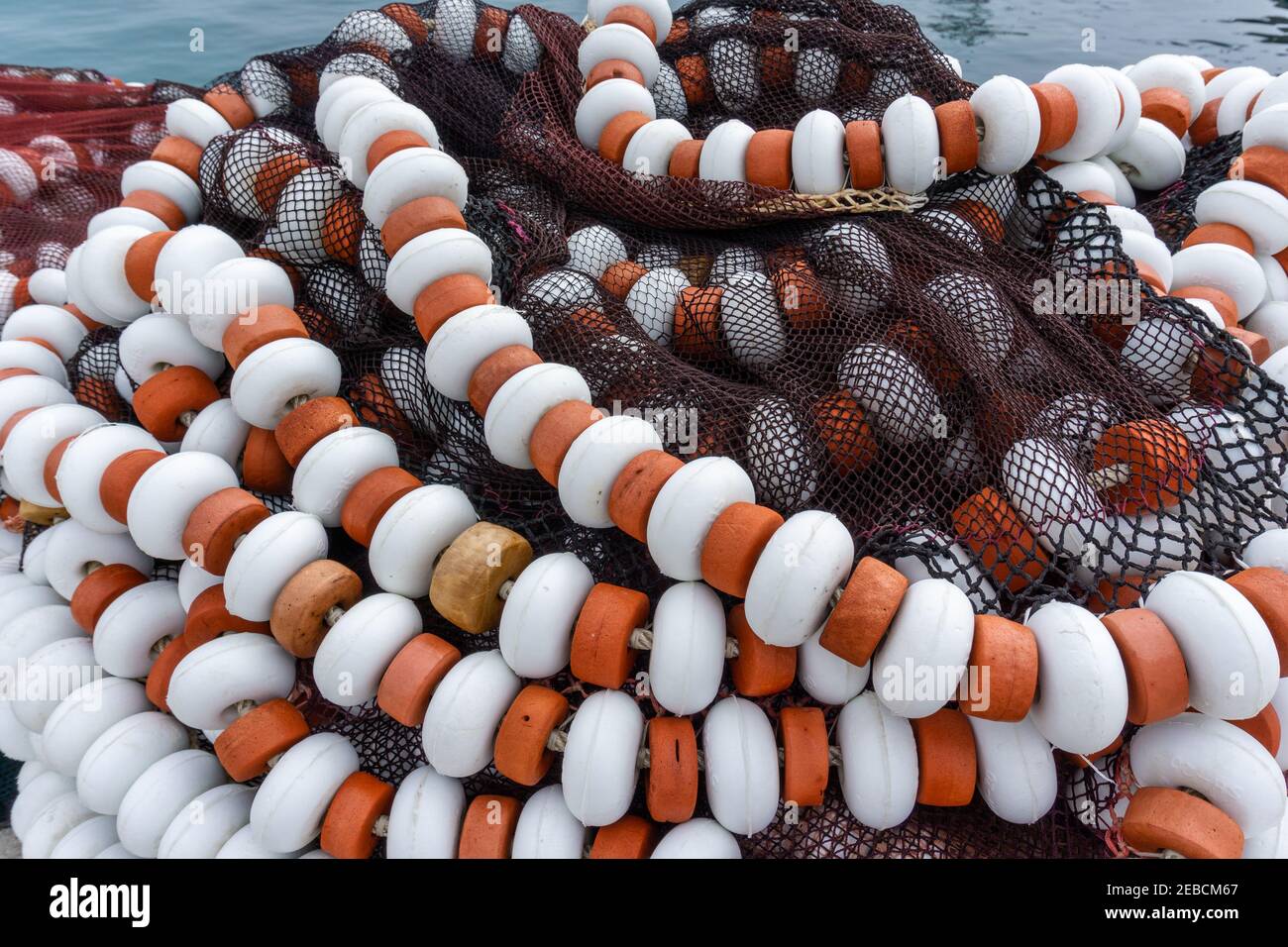 Una vista ravvicinata delle reti da pesca e da traino a grappolo insieme su un molo nel porto Foto Stock