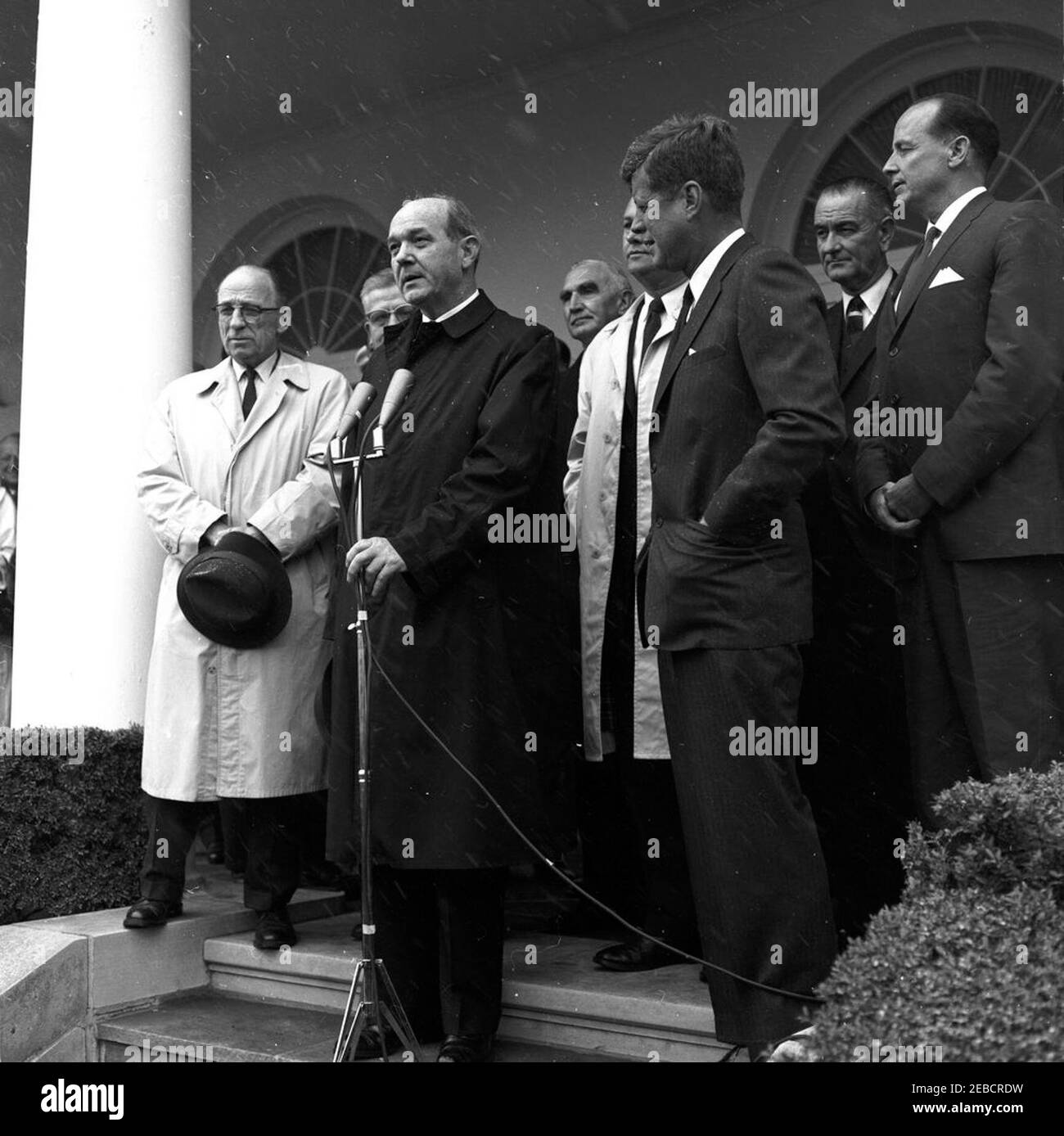 Cerimonia di benvenuto al ritorno della delegazione degli Stati Uniti alla Conferenza di Punta del Este, alle 14:10. Il Segretario di Stato Dean Rusk parla del ritorno della delegazione alla Conferenza di Punta del Este in Uruguay. (L-R) Senatore Bourke Hickenlooper dell'Iowa; Rappresentante Chester Merrow del New Hampshire (parzialmente nascosto); Segretario Rusk; Senatore Wayne Morse dell'Oregon; Rappresentante Armistead Selden, Jr. Dell'Alabama; Presidente John F. Kennedy; Vice Presidente Lyndon B. Johnson; DeLesseps Morrison, Ambasciatore degli Stati Uniti presso l'Organizzazione degli Stati americani. La caduta di neve è visibile. Rosa Garde Foto Stock