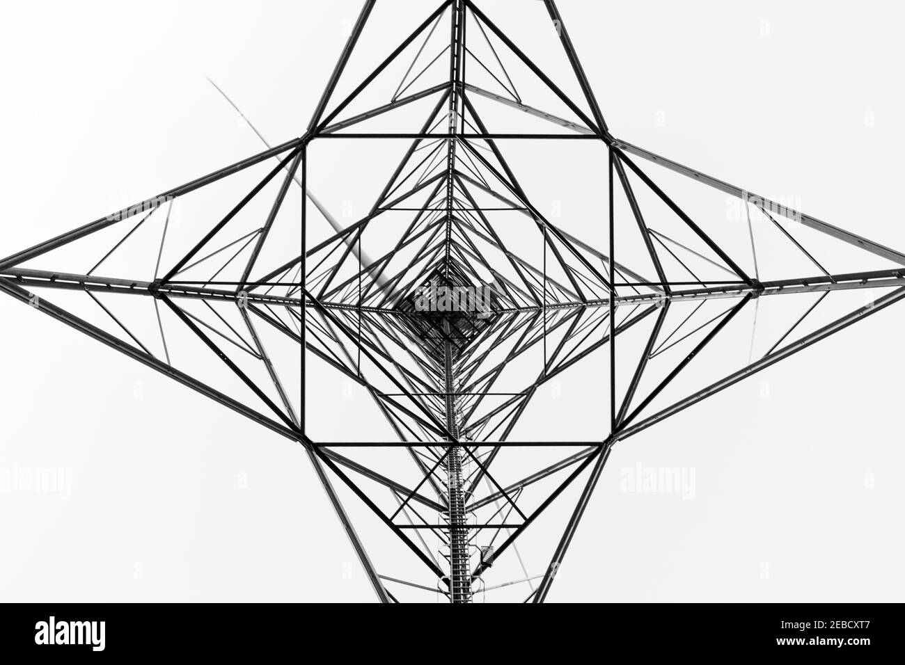 Silhouette di una turbina eolica in bianco e nero. Quadrati e triangoli formano forme simmetriche. Ritagliare il modello di progetto. Vista ad angolo basso, concentrica. Foto Stock