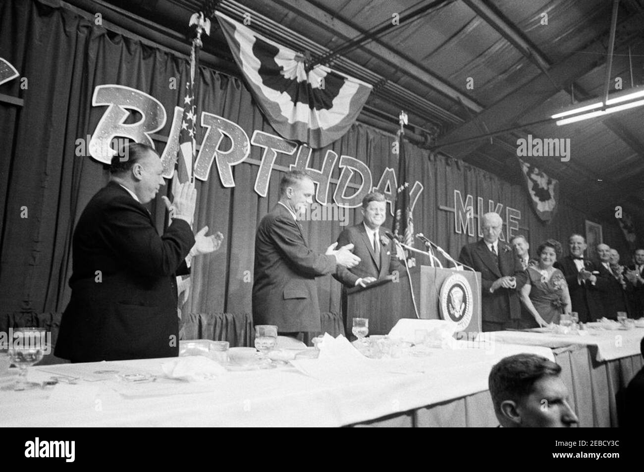 Raccolta di fondi democratica e cena di compleanno a Columbus, Ohio, in onore del governatore Michael DiSalle dell'Ohio, 19:05. Il presidente John F. Kennedy parla alla festa di compleanno del governatore dell'Ohio Michael DiSalleu2019s. (L-R) Governatore DiSalle; William L. Coleman, Presidente del Comitato Esecutivo democratico dell'Ohio; Presidente Kennedy; Presidente della Corte Suprema dell'Ohio Carl V. Weygandt; Senatore Frank J. Lausche dell'Ohio; Myrtle Eugene England DiSalle, moglie del Governoru2019s; quattro non identificati. Win Lawson, agente del Servizio segreto della Casa Bianca, si trova in basso a destra in primo piano. Buckeye Building, Ohio state Fair Foto Stock