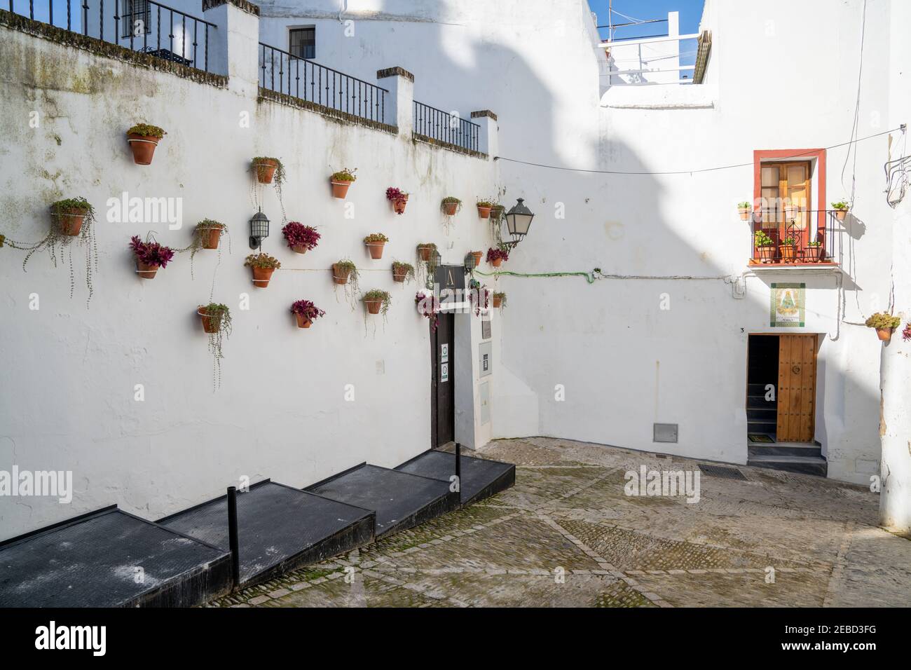 Arcos de la Frontera, Spagna - 27 gennaio 2021: Edifici in stile architettonico spagnolo con pareti bianche e vasi di fiori Foto Stock