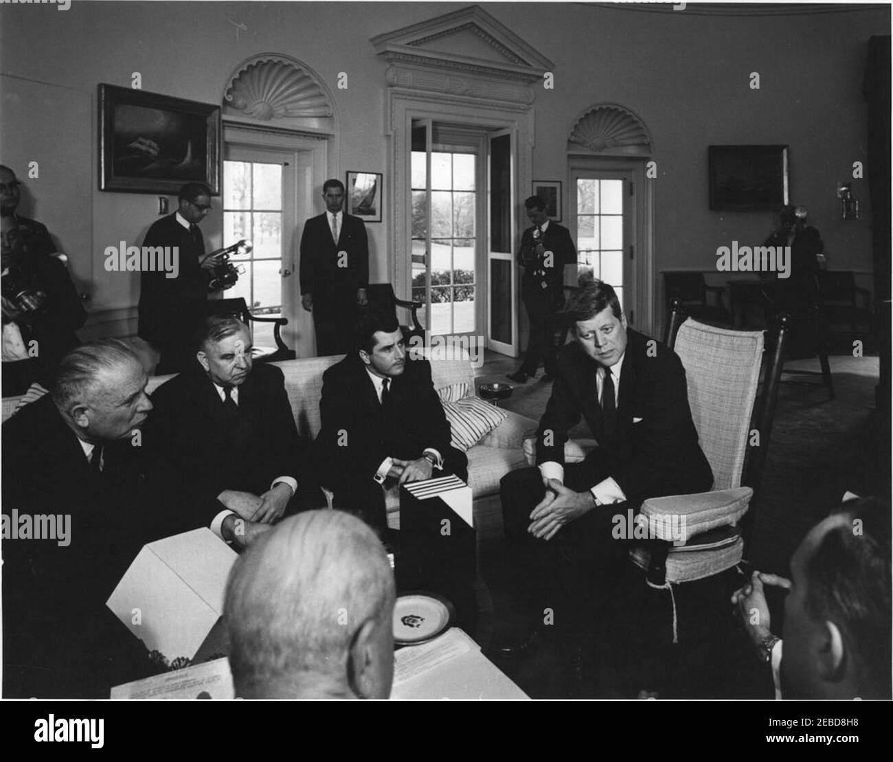 Incontro con la Commissione americana per i diritti civili, ORE 12:35. Il presidente John F. Kennedy incontra i membri della Commissione per i diritti civili degli Stati Uniti nell'Ufficio ovale, Casa Bianca, Washington, D.C. seduto (L-R): John A. Hannah, presidente; Erwin N. Griswold; Berl I. Bernhard; e il presidente Kennedy (in sedia a dondolo). Fotografi in background. Foto Stock