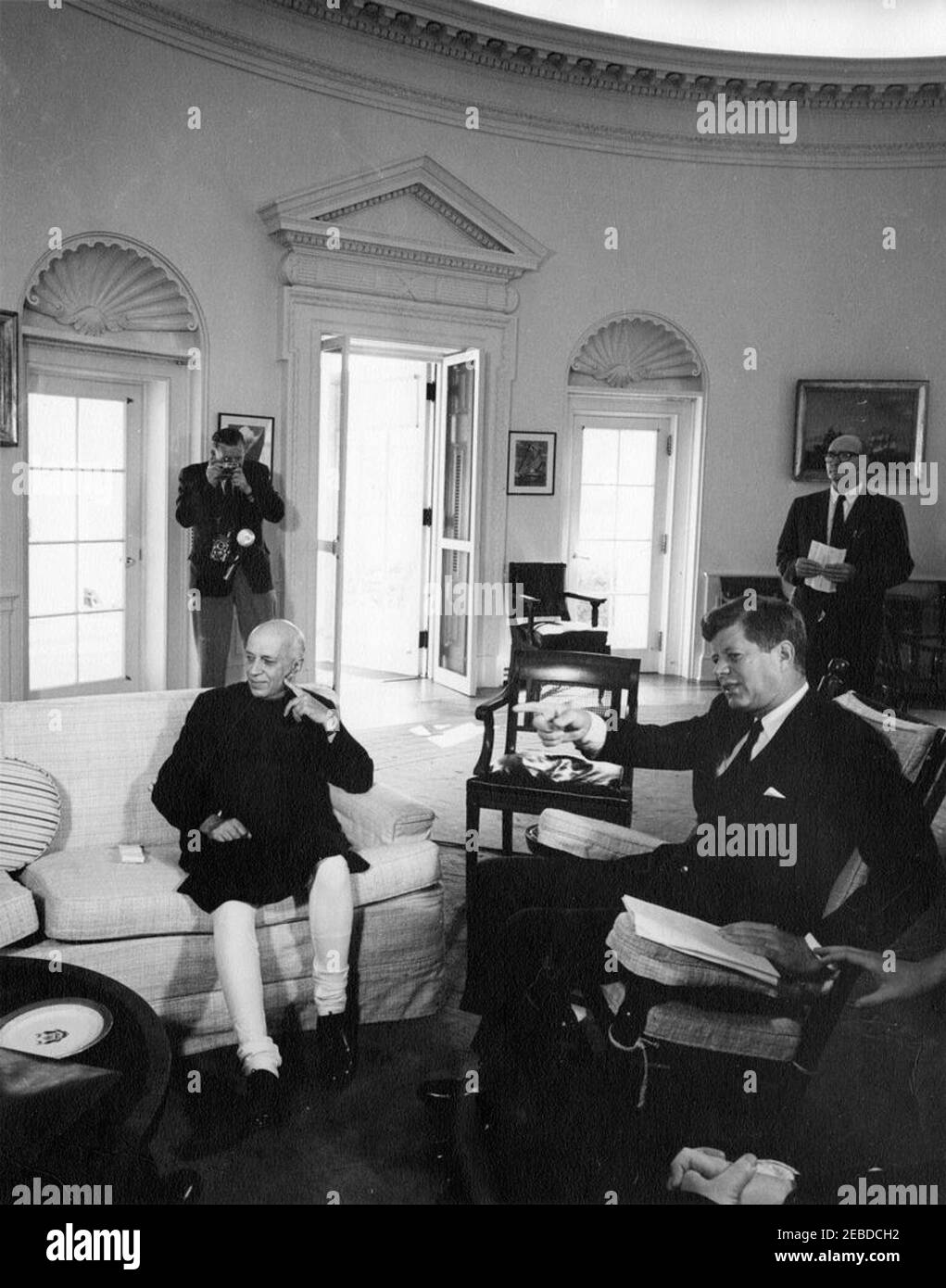 Incontro con Jawaharlal Nehru, primo Ministro dell'India, ore 10. Il presidente John F. Kennedy (seduto a dondolo) incontra il primo ministro indiano Jawaharlal Nehru. Assistente speciale del presidente Dave Powers e un fotografo non identificato stanno sullo sfondo. Ufficio ovale, Casa Bianca, Washington, D.C. Foto Stock