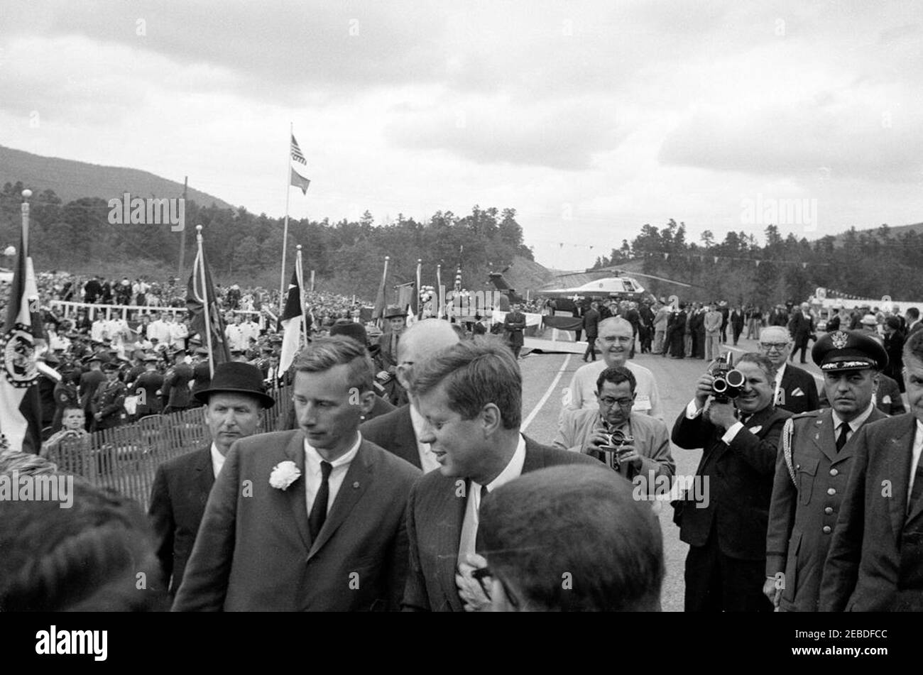 Viaggio in Oklahoma: Cerimonia di taglio del nastro a Ouachita National Park Road, Big Cedar, Oklahoma. Il presidente John F. Kennedy partecipa alla cerimonia di taglio del nastro a Ouachita National Forest Road. Presidente Kennedy (al centro); Air Force Aide al Presidente Brigadier Generale Godfrey T. McHugh (secondo da destra); Agente di Servizio Segreto Gerald u201cJerryu201d Behn (all'estrema destra, parzialmente fuori quadro); altri non identificati. Big Cedar, Oklahoma. Foto Stock