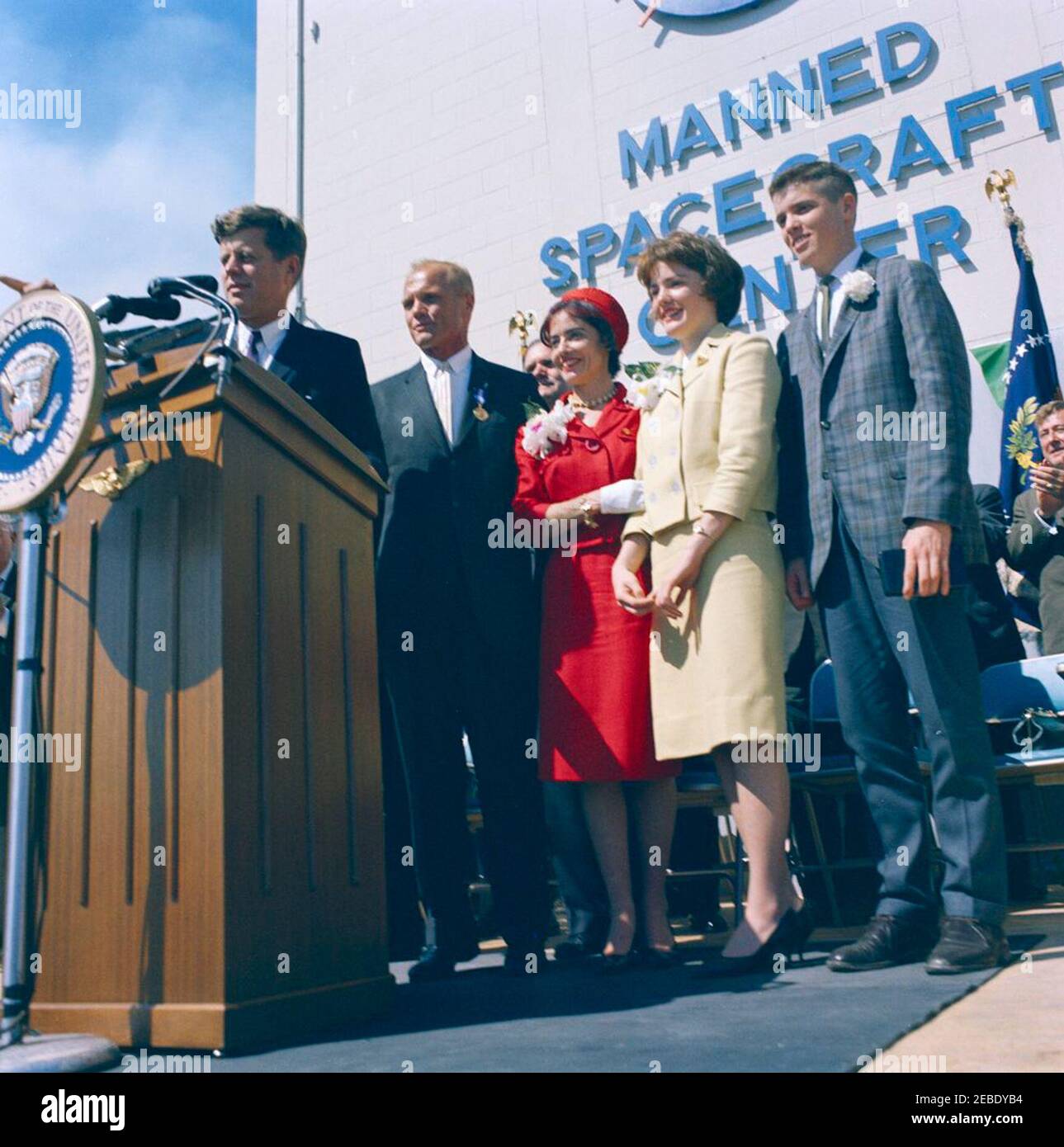 Presentazione della NASA (National Aeronautics and Space Administration) Distinguished Service Medal (DSM) all'astronauta John Herschel Glenn, Jr., a Cape Canaveral. L'astronauta tenente colonnello John H. Glenn, Jr. (A destra della lanterna) si trova con sua moglie, Annie Glenn (vestita rossa), figlia, Lyn Glenn (vestita gialla), E il figlio, David Glenn, dopo aver ricevuto la National Aeronautics and Space Administration (NASA) Distinguished Service Medal dal presidente John F. Kennedy (al leggio) a Hangar u2018S,u2019 Cape Canaveral Air Force Station, Brevard County, Florida. Amministratore di NA Foto Stock