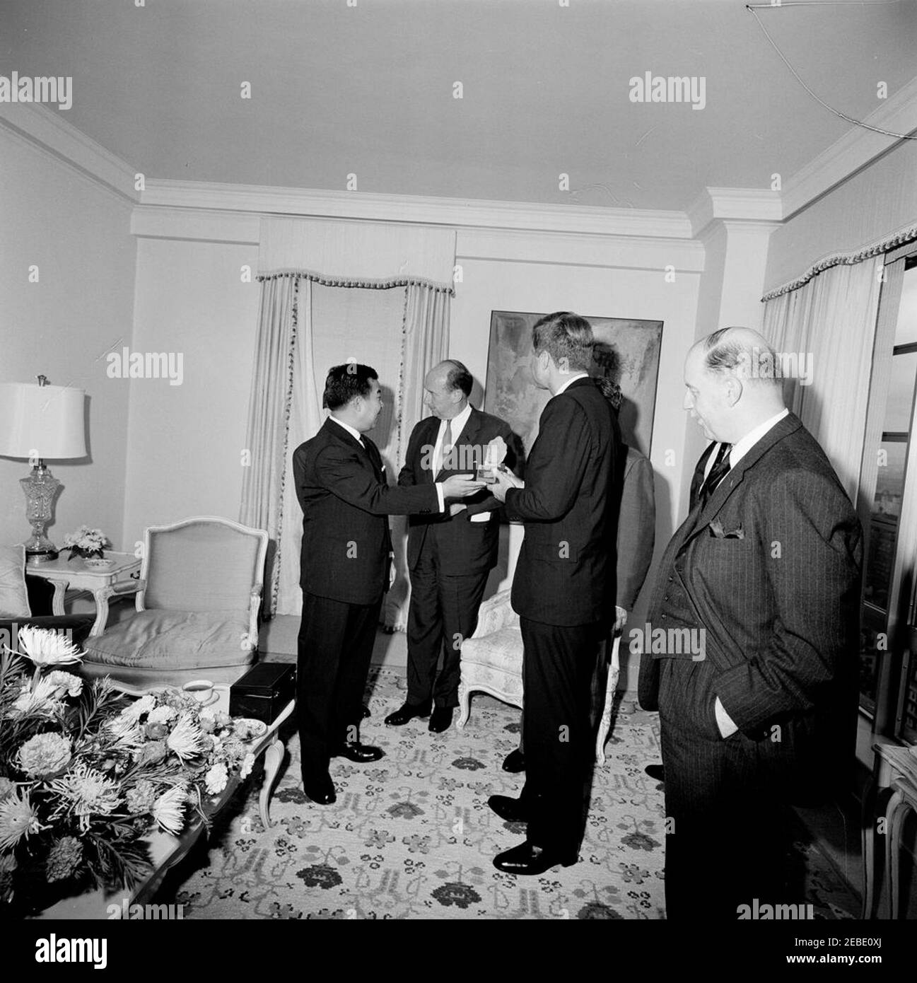Viaggio a New York: Incontro con il Principe Norodom Sihanouk di Cambogia, alle 16:00. Il presidente John F. Kennedy detiene una piccola statua presentata dal principe Norodom Sihanouk della Cambogia nella Suite del Presidente 2019s al Carlyle Hotel, New York City, New York. (L-R) il principe Sihanouk; l'ambasciatore degli Stati Uniti presso le Nazioni Unite Adlai Stevenson; il presidente Kennedy; il ministro degli Affari Esteri della Cambogia Nhiek Tioulong (per lo più nascosto dietro il presidente Kennedy); John Steeves, vice segretario di Stato aggiunto per gli Affari dell'Estremo Oriente. Foto Stock