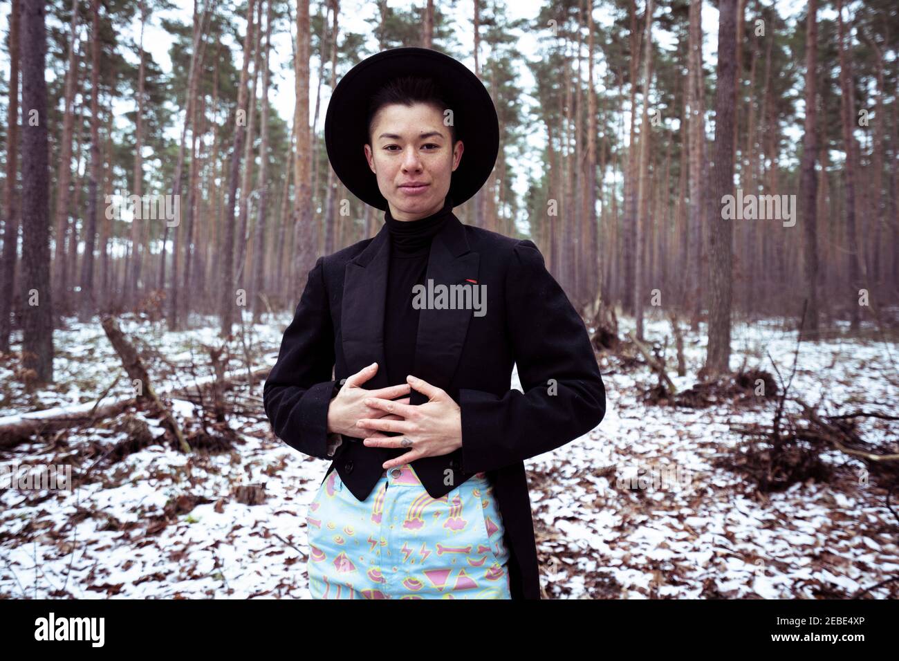 Queer donna trendy si trova in bianco europa Forrest durante l'inverno Foto Stock