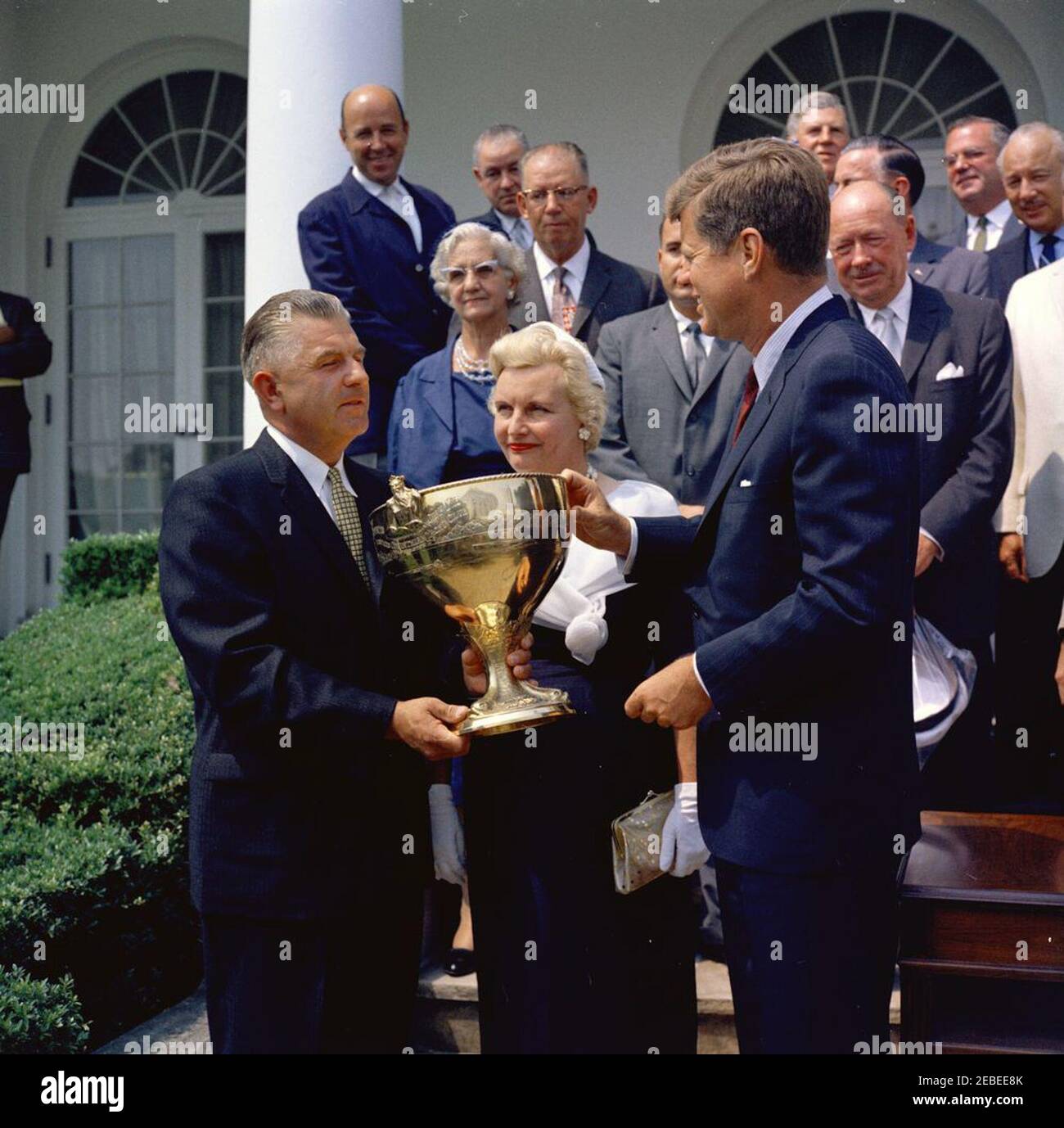 Presentazione del Trofeo Regatta della Coppa Presidentu0027s 1960, ore 12:06. Il presidente John F. Kennedy presenta un trofeo a Charles u201cChucku201d Thompson, il vincitore della Regata della Coppa del Presidente 1960, nel Rose Garden, White House, Washington, D.C. la moglie di Winneru2019s, Christine Thompson, guarda sopra. Altri includono: Naval Aide al presidente Tazewell Shepard, Jr.; Raymond Bettmann e sua moglie (nome sconosciuto); John carter e sua moglie (nome sconosciuto); Roy Chalk; presidente della Presidentu2019s Cup Regatta Association Edward R. Carr; presidente della Presidentu2019s Cup Regatta 1961 Foto Stock