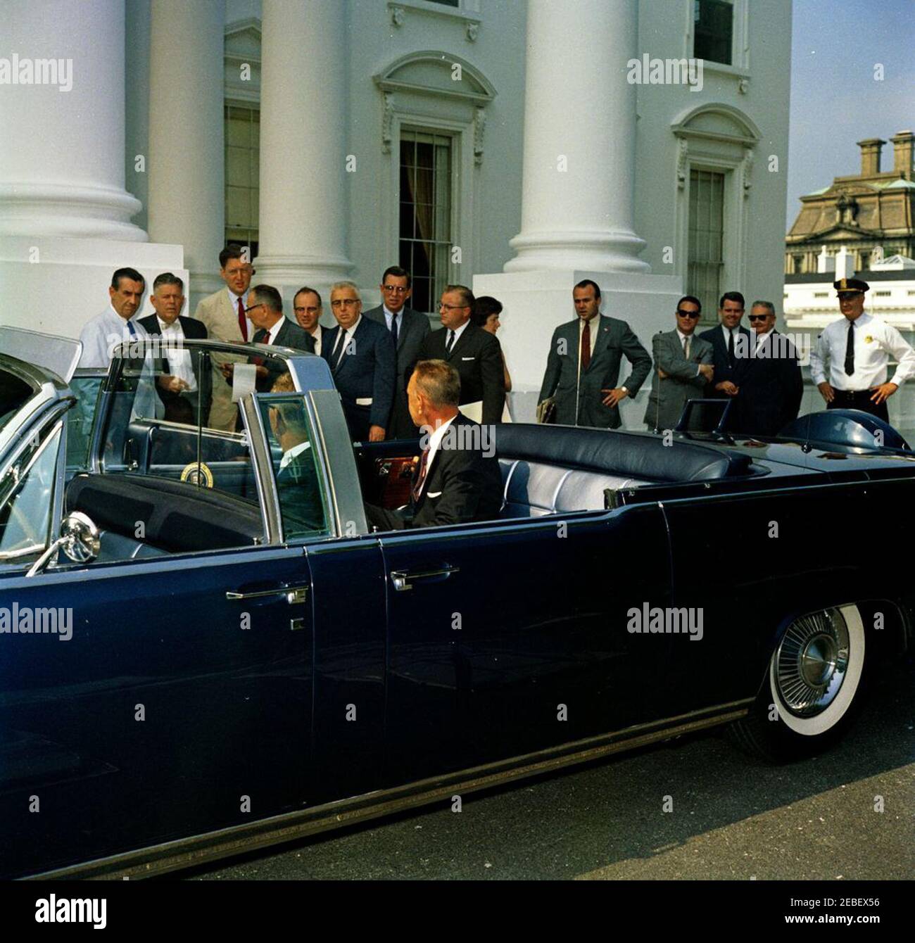 Nuova limousine presidenziale. Arrivo della nuova limousine presidenziale (Lincoln-Mercury Continental convertibile), costruita dalla Ford Motor Company e personalizzata da Hess u0026 Eisenhardt. Il direttore del servizio segreto degli Stati Uniti, U. E. Baughman, siede nel sedile posteriore dell'automobile. Anche nella foto: decano del corpo stampa della Casa Bianca e reporter della United Press International (UPI), Merriman u0022Smittyu0022 Smith; corrispondente della Casa Bianca per la Washington Star, Garnett D. Horner; corrispondente della Casa Bianca per NBC, Sander Vanocur; Agente di Servizio Segreto della Casa Bianca John J. u0022Muggsyu0022 Ou0027Lear Foto Stock