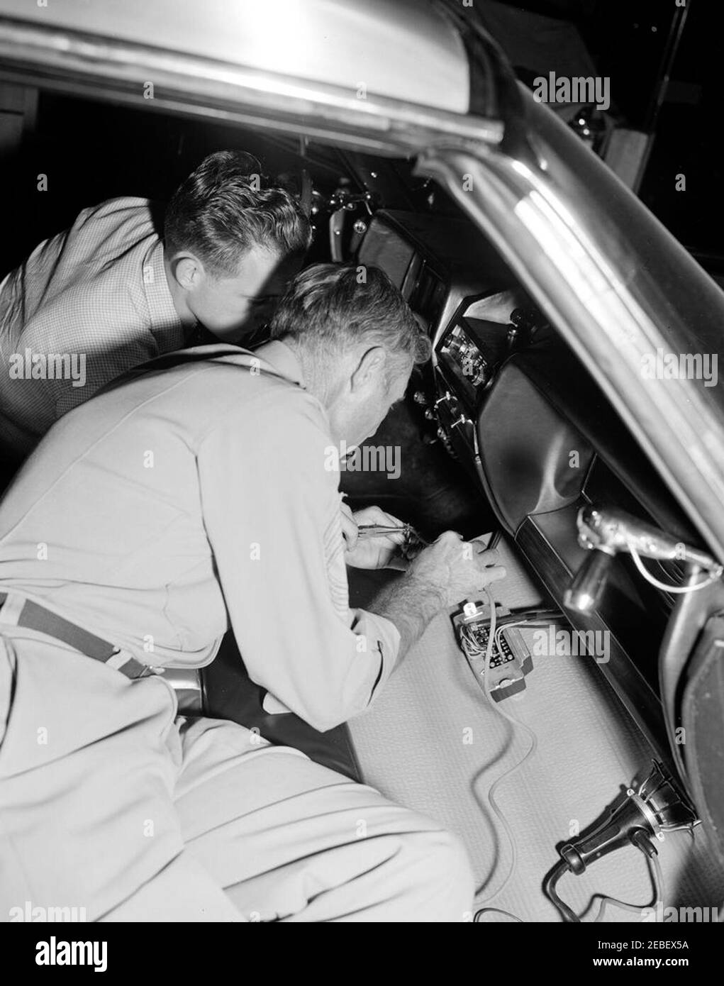 Installazione di attrezzature della White House Army Signal Agency (WHASA) in una nuova limousine. Due membri dello staff della White House Army Signal Agency (WHASA) non identificati (uno con un'insegna del Master Sergeant sul braccio) installano l'attrezzatura WHASA nel cruscotto della nuova limousine presidenziale Lincoln-Mercury Continental. [Fotografia di Harold Sellers] Foto Stock