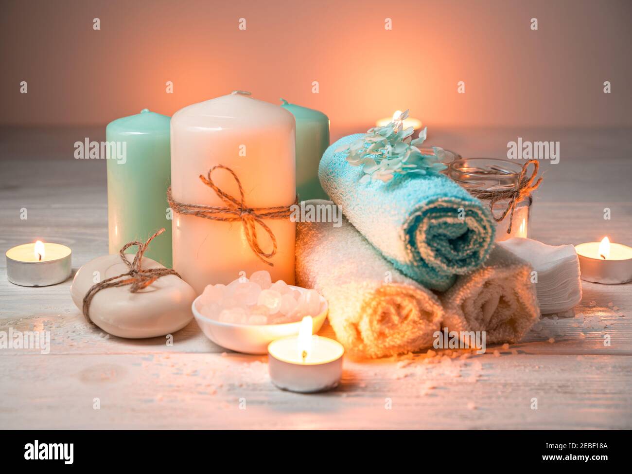 Un insieme di prodotti per la cura del corpo con candele brucianti. Foto Stock