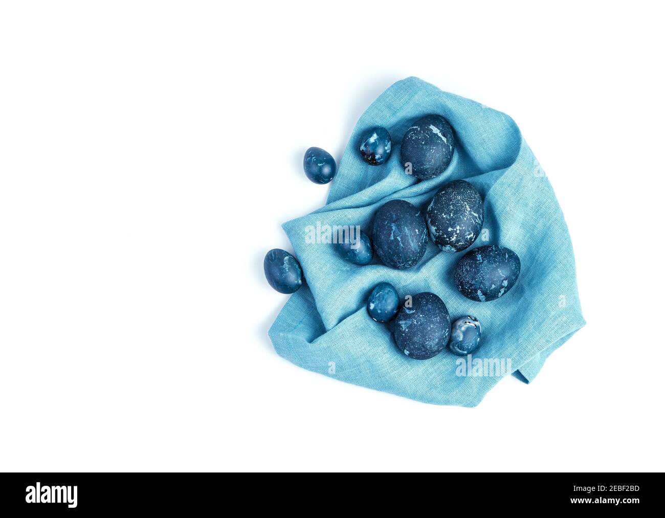 Un set di uova di Pasqua blu scuro su un tovagliolo blu. Foto Stock