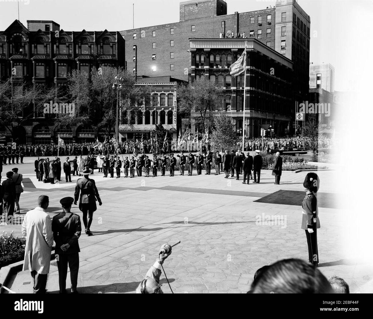 Viaggio a Ottawa, Canada: Cerimonia di deposizione della corona al National War Memorial, Ottawa, Canada, 9:30. Il presidente John F. Kennedy viene a Confederation Square a Ottawa, Ontario, Canada, per porre una corona al National War Memorial. I veterani canadesi si trovano al centro della Royal Union Flags (Union Jacks). [Fotografia di Harold Sellers] [il difetto a destra dell'immagine è originale al negativo.] Foto Stock
