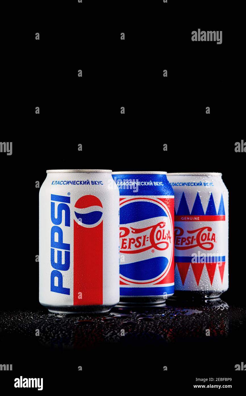 MOGILEV, BIELORUSSIA - GENNAIO 29 2021: Tre lattina di Pepsi cola in diversi pacchetti su sfondo nero, Pepsi è una bevanda analcolica gassata prodotta Pep Foto Stock