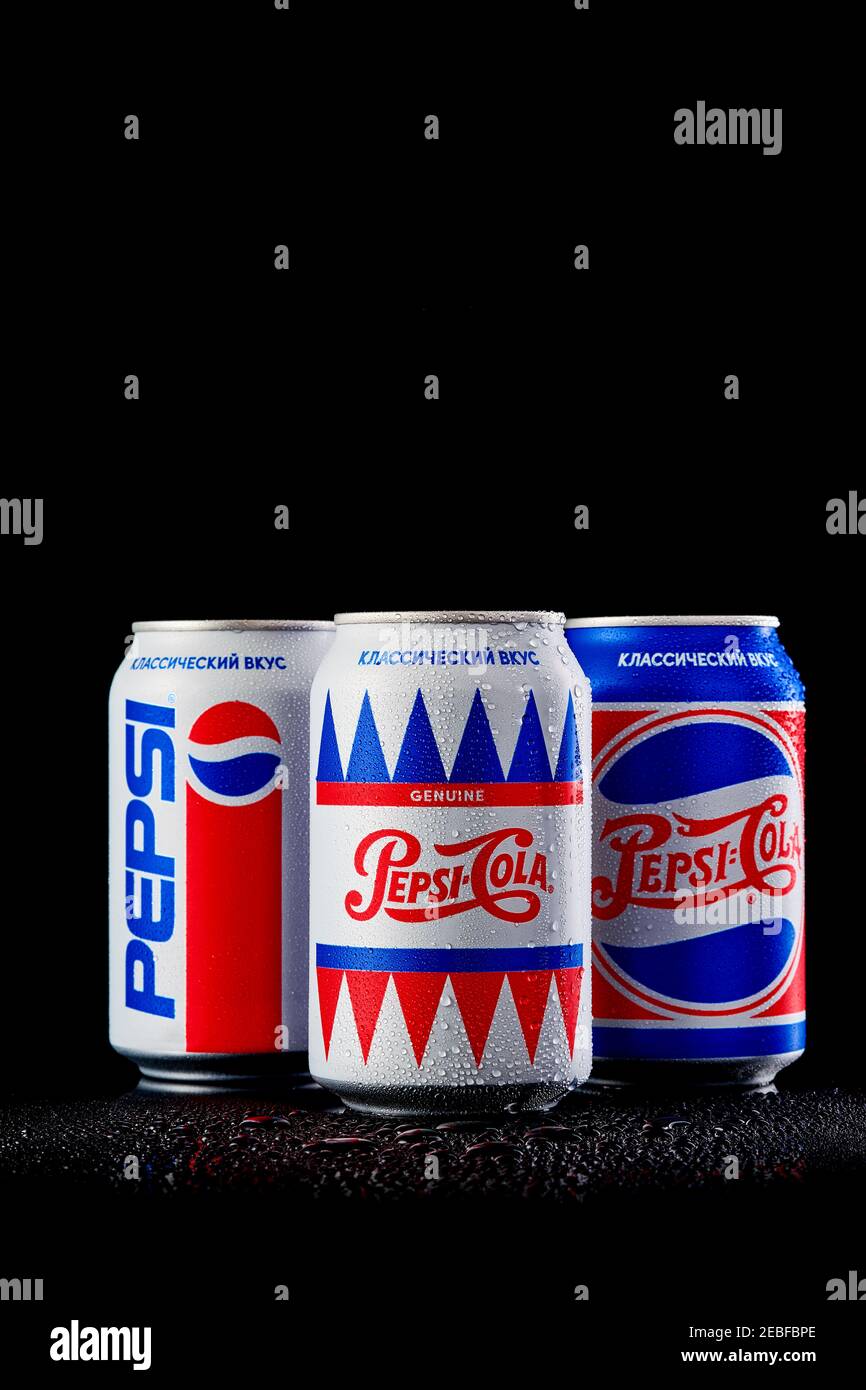MOGILEV, BIELORUSSIA - GENNAIO 29 2021: Tre lattina di Pepsi cola in diversi pacchetti su sfondo nero, Pepsi è una bevanda analcolica gassata prodotta Pep Foto Stock