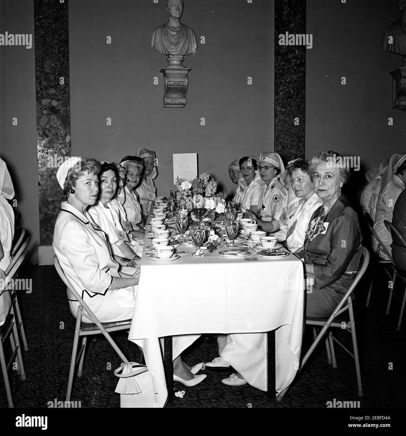 First Lady Jacqueline Kennedy (JBK) partecipa al Senato Ladies Red Cross Unit Luncheon. I membri dell'unità della Croce Rossa delle Signore del Senato partecipano ad un pranzo nella Camera della Corte Suprema Vecchia, edificio del Campidoglio degli Stati Uniti, Washington, D.C. l'unità della Croce Rossa (conosciuta anche come u201cLadies del Senateu201d) è composta dalle mogli dei membri del Senato degli Stati Uniti. Da sinistra a destra: ERMA Lee Udall (moglie del Segretario dell'interno, Stewart L. Udall); Lucretia Engle (moglie del senatore Clair Engle della California); Ana Allen Cordon (moglie dell'ex senatore Guy Cordon dell'Oregon); non identificato; Dorothy Wiley (moglie di Foto Stock