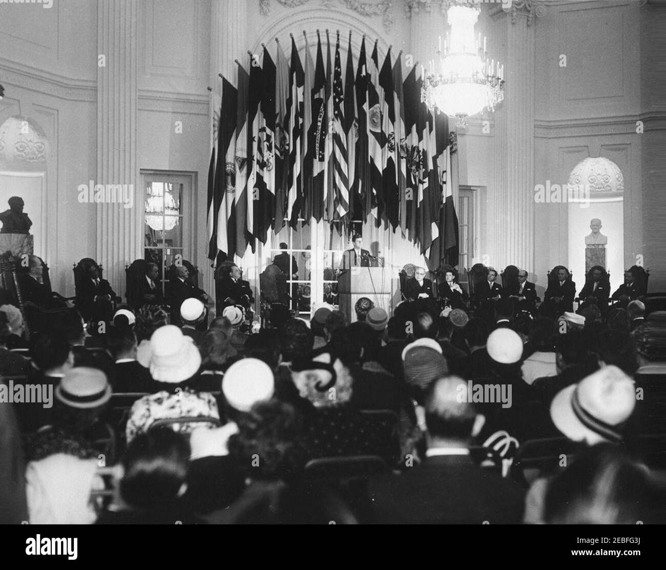 Indirizzo al Pan American Union Building, 10:53. Il presidente John F. Kennedy parla durante la sessione protocollaria del Consiglio dell'Organizzazione degli Stati americani (OAS) presso il Pan American Union Building di Washington, D.C. altri in scena includono il rappresentante dell'OAS Vicente Sau0301nchez Gavito del Messico; il rappresentante dell'OAS Juan Bautista Lavalle del Perù; Rappresentante dell'OAS Guillermo Sevilla Sacassa del Nicaragua; Segretario Generale dell'Unione Panamericana Dr. Josu00e9 Mora. Foto Stock