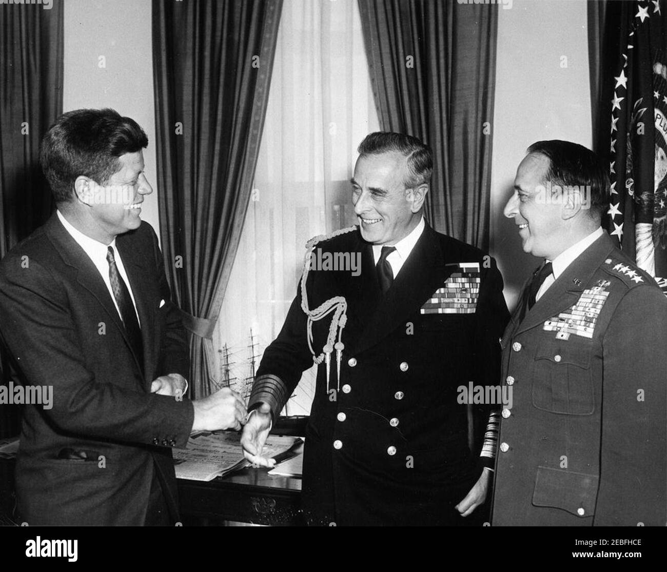 Incontro con l'ammiraglio della flotta Lord Louis Mountbatten, 1° conte Mountbatten di Birmania, 10:25. Il presidente John F. Kennedy incontra il capo del personale di difesa delle forze armate britanniche Lord Louis Mountbatten, primo conte Mountbatten di Birmania (centro) e il presidente dei capi congiunti del personale generale Lyman Lemnitzer (destra) nell'ufficio ovale, Casa Bianca, Washington, D.C. Foto Stock