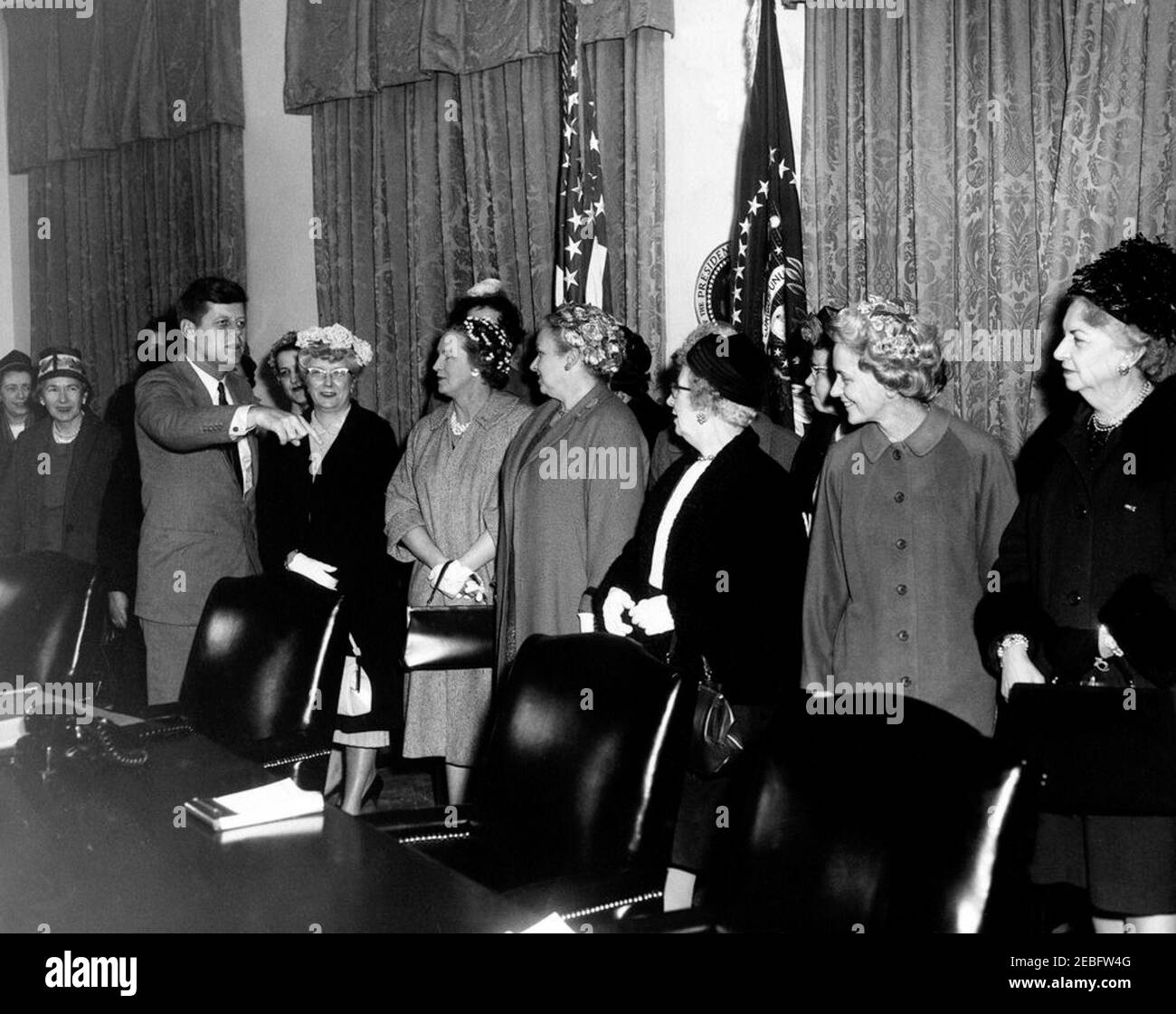Visita dei rappresentanti del Consiglio Nazionale delle Donne Cattoliche, ore 16:20. Visita dei rappresentanti del Consiglio Nazionale delle Donne Cattoliche. Il presidente John F. Kennedy, con sedici donne non identificate. Le donne non identificate possono includere: Presidente del Consiglio Nazionale delle Donne Cattoliche, Elizabeth A. Zepf. Sala armadio, Casa Bianca, Washington, D.C. Foto Stock