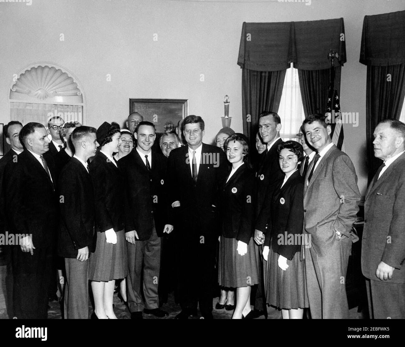 Visita dei membri del Club 4-H alle 10:45. Il presidente John F. Kennedy visita con i soci del Club 4-H in relazione alla settimana nazionale del Club 4-H. I vincitori sono stati selezionati per i loro risultati eccezionali nel lavoro di club. L-R: Quattro persone non identificate (tre parzialmente nascoste); William Platt III (Gainesville, Florida); ragazza non identificata; donna non identificata; uomo non identificato (dietro); Robert Barr (Port Matilda, Pennsylvania); due persone non identificate (una con faccia nascosta dietro il presidente Kennedy); presidente John F. Kennedy; donna non identificata (dietro); Joyce Finnell (Cleveland, Tennessee); non identificata Foto Stock