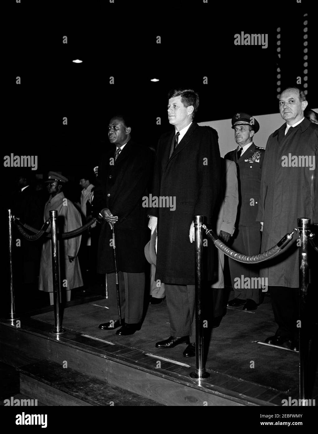 Cerimonia di arrivo per Kwame Nkrumah, presidente del Ghana, 15:43. Il presidente John F. Kennedy partecipa alle cerimonie di arrivo in onore del presidente della Repubblica del Ghana, Osagyefo Dr. Kwame Nkrumah. Sulla piattaforma (L-R): Presidente Nkrumah; Presidente Kennedy; Presidente dei Capi di Stato congiunti, Generale Lyman Lemnitzer; Segretario di Stato, Dean Rusk. Anche nella foto: Assistente capo del protocollo per visite ed eventi pubblici, Samuel L. re. Hangar n. 10, Terminal del Servizio militare di trasporto aereo (MATS), Aeroporto Nazionale di Washington, Washington, D.C. Foto Stock