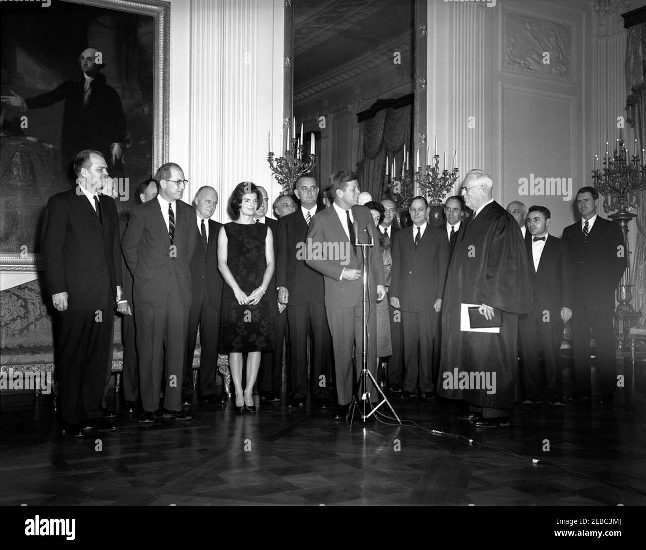 Cerimonia di giuramento e ricevimento per segretari aggiunti e altri nominati Presidenti, alle 17:10. Cerimonia di giuramento e accoglienza per segretari assistenti e nominati Presidenti, East Room, White House, Washington, D.C. il presidente John F. Kennedy si rivolge al gruppo come capo della giustizia Earl Warren guarda da destra. Il gruppo comprende: Vice procuratore generale Byron White; Vice Postmaster generale H.W. Brawley; Segretario aggiunto della Difesa Thomas Morris; Segretario aggiunto della Difesa Paul Nitze; Segretario aggiunto della Difesa Arthur Sylvester; Sottosegretario dell'Aeronautica militare Joseph CH Foto Stock