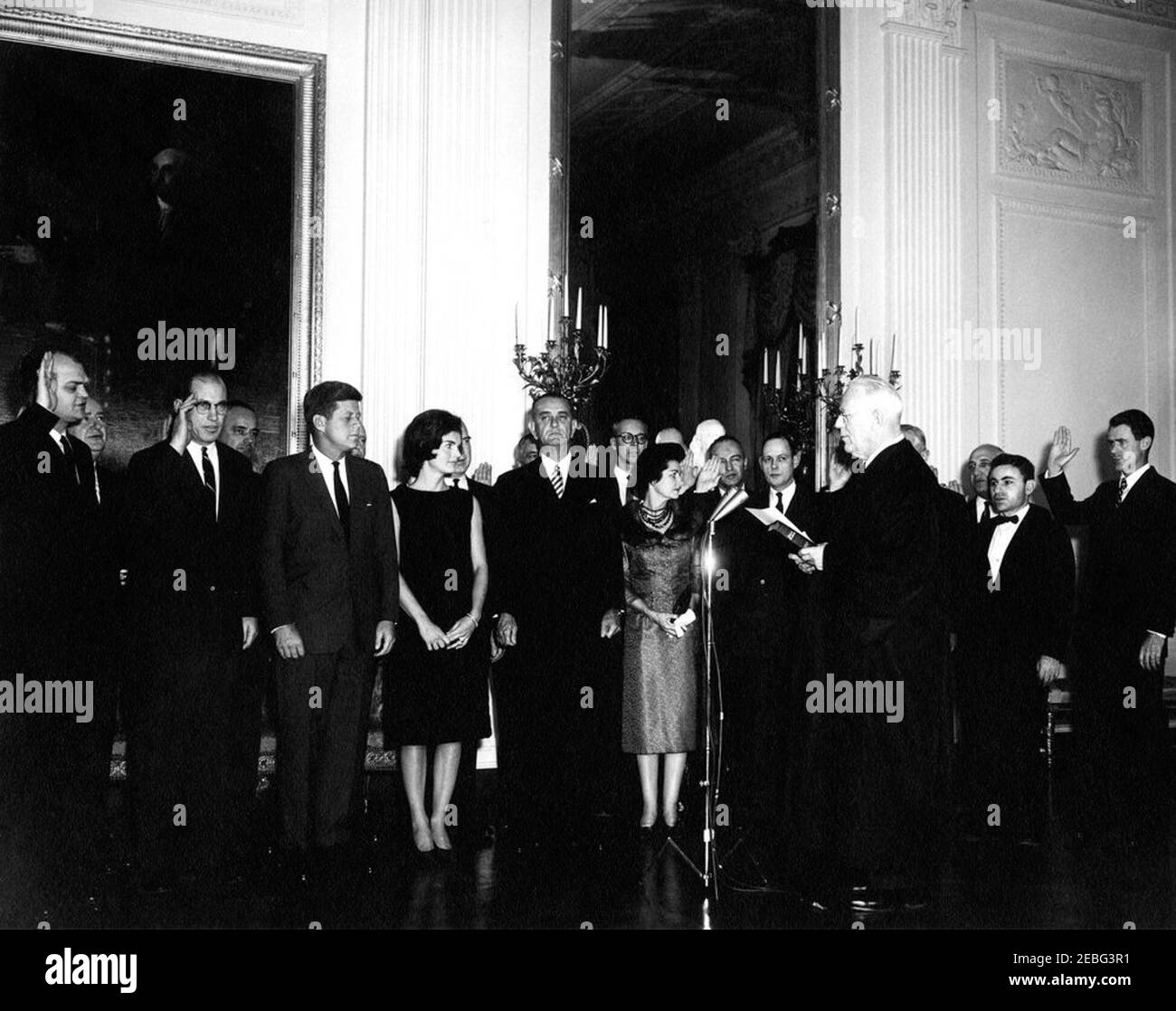 Cerimonia di giuramento e ricevimento per segretari aggiunti e altri nominati Presidenti, alle 17:10. Cerimonia di giuramento e accoglienza per segretari assistenti e nominati Presidenti, East Room, White House, Washington, D.C. il Conte responsabile Giustizia Warren giura in gruppo che comprende: Vice procuratore generale Byron White; Vice Postmaster generale H.W. Brawley; Assistente Segretario della Difesa Thomas Morris; Assistente Segretario della Difesa Paul Nitze; Assistente Segretario della Difesa Arthur Sylvester; sotto Segretario dell'Aeronautica militare Joseph Charyk; Assistente Segretario della Marina James Wakelin Foto Stock