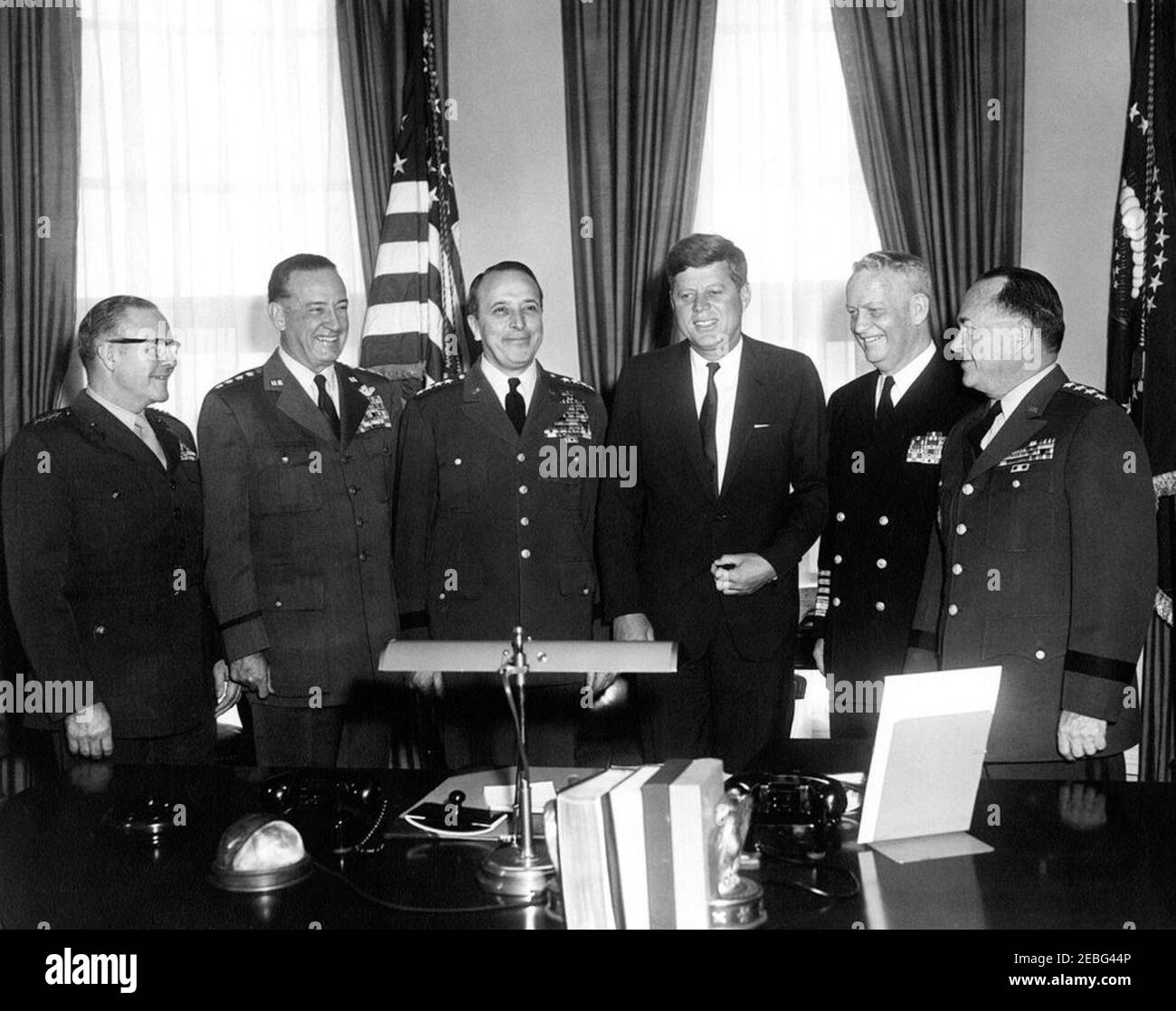 Incontro con i Capi congiunti del personale (JCS), ore 10:12. Il presidente Kennedy incontra i capi di Stato e di Stato maggiore. (L-R) Comandante del generale del corpo marino degli Stati Uniti David M. Shoup; Capo di Stato maggiore del generale dell'aeronautica degli Stati Uniti Thomas D. White; Presidente dei Capi congiunti del personale generale Lyman Lemnitzer; Presidente Kennedy; Capo di Stato maggiore dell'ammiraglio della marina degli Stati Uniti Arleigh A. Burke; Capo di stato maggiore del generale dell'esercito degli Stati Uniti George H. Decker. Ufficio ovale, Casa Bianca, Washington, D.C. Foto Stock