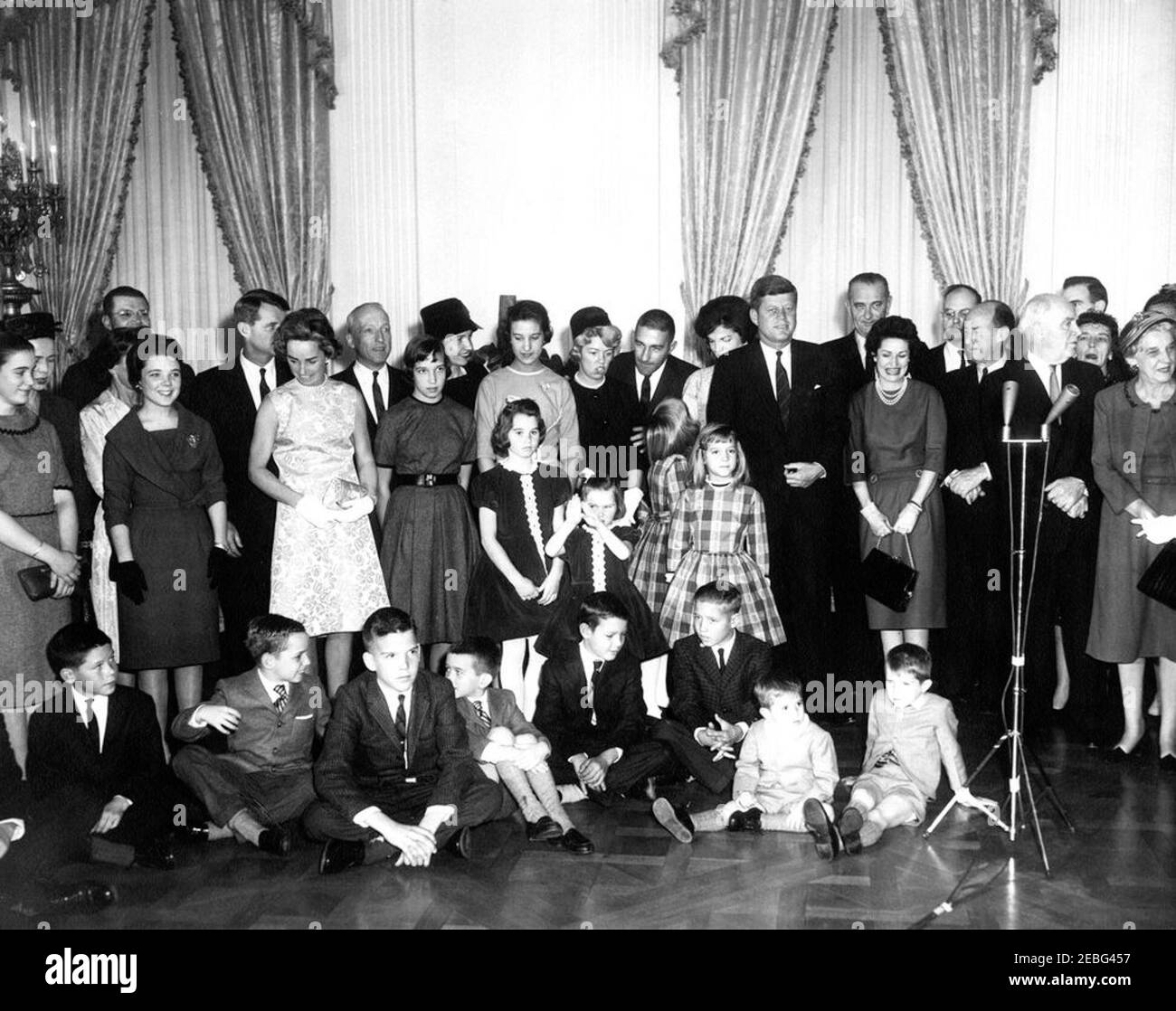 Cerimonia di giuramento e ricevimento per segretari di Gabinetto, ore 16:00. Giurando in cerimonia e accoglienza per i membri del gabinetto e le loro famiglie, East Room, White House, Washington, D.C. i membri del gabinetto appena giurati e le loro famiglie si pongono con il presidente John F. Kennedy e la First Lady Jacqueline Kennedy. La foto include: Il Segretario della Difesa Robert S. McNamara e la moglie Margaret McNamara; il Procuratore Generale Robert F. Kennedy e la moglie Ethel Kennedy; il Postmaster Generale J. Edward Day e la moglie Mary Louise Day; Erma Lee Udall con il marito Segretario dell'interno Stewart Udall; Jacqueline Kennedy e P. Foto Stock