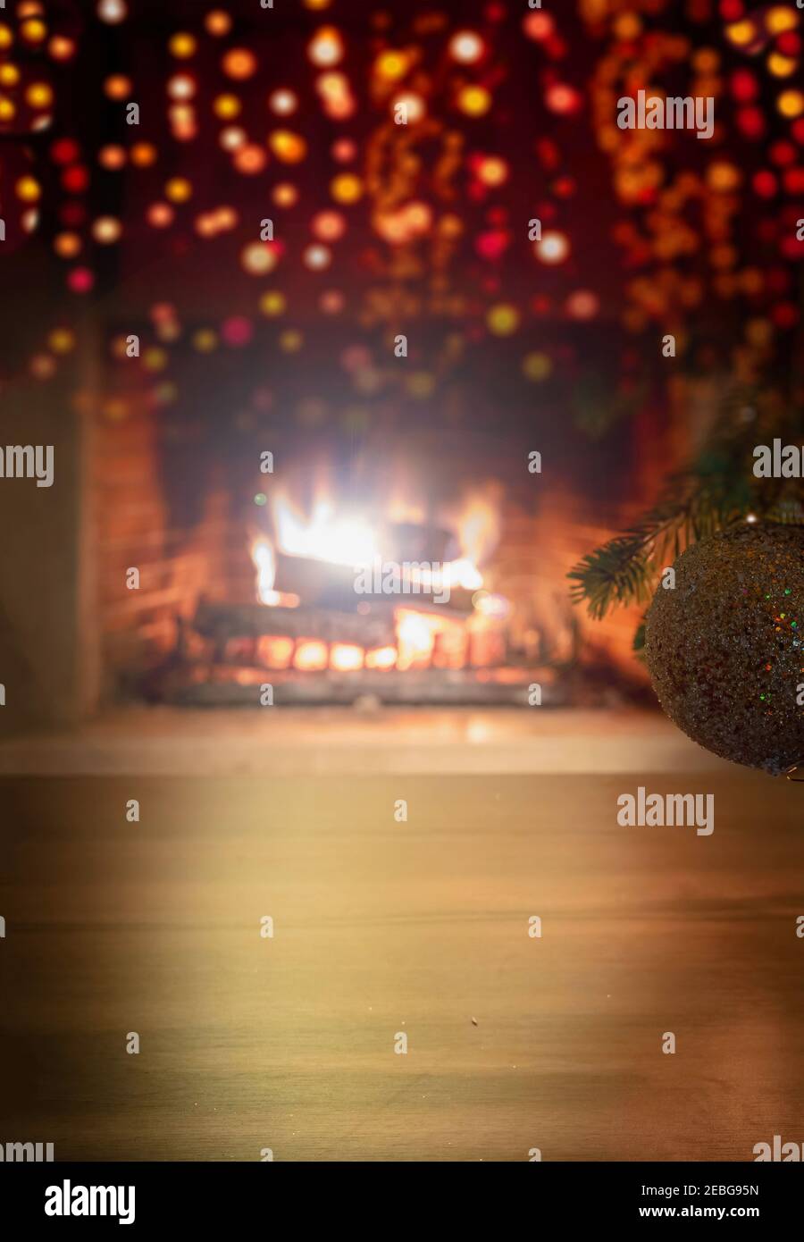 Concetto di festa interna di Natale. Vista ravvicinata verticale del ramo dell'albero di Natale con palla scintillante d'argento e fuoco di bokeh che brucia Foto Stock