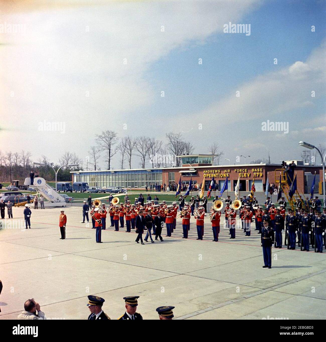 Cerimonia di arrivo per Jou00e3o Goulart, Presidente del Brasile, ore 10:00. Comandante non identificato delle truppe scorta il presidente John F. Kennedy (a sinistra, cappello di tenuta) e il presidente del Brasile Jou00e3o Goulart durante le cerimonie di arrivo alla base dell'aeronautica di Andrews, Maryland. La U.S. Marine Band gioca sullo sfondo; le truppe militari della guardia d'onore degli Stati Uniti si trovano all'estrema destra. Foto Stock