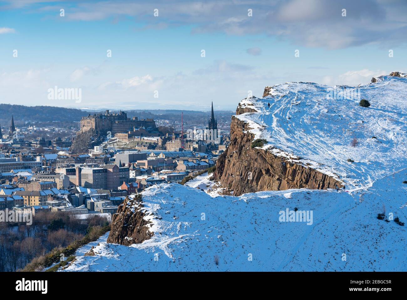 Vista dei salti di Salisbury coperti di neve in inverno a Holyrood Park con Castello di Edimburgo a ritroso, Edimburgo, Scozia, Regno Unito Foto Stock