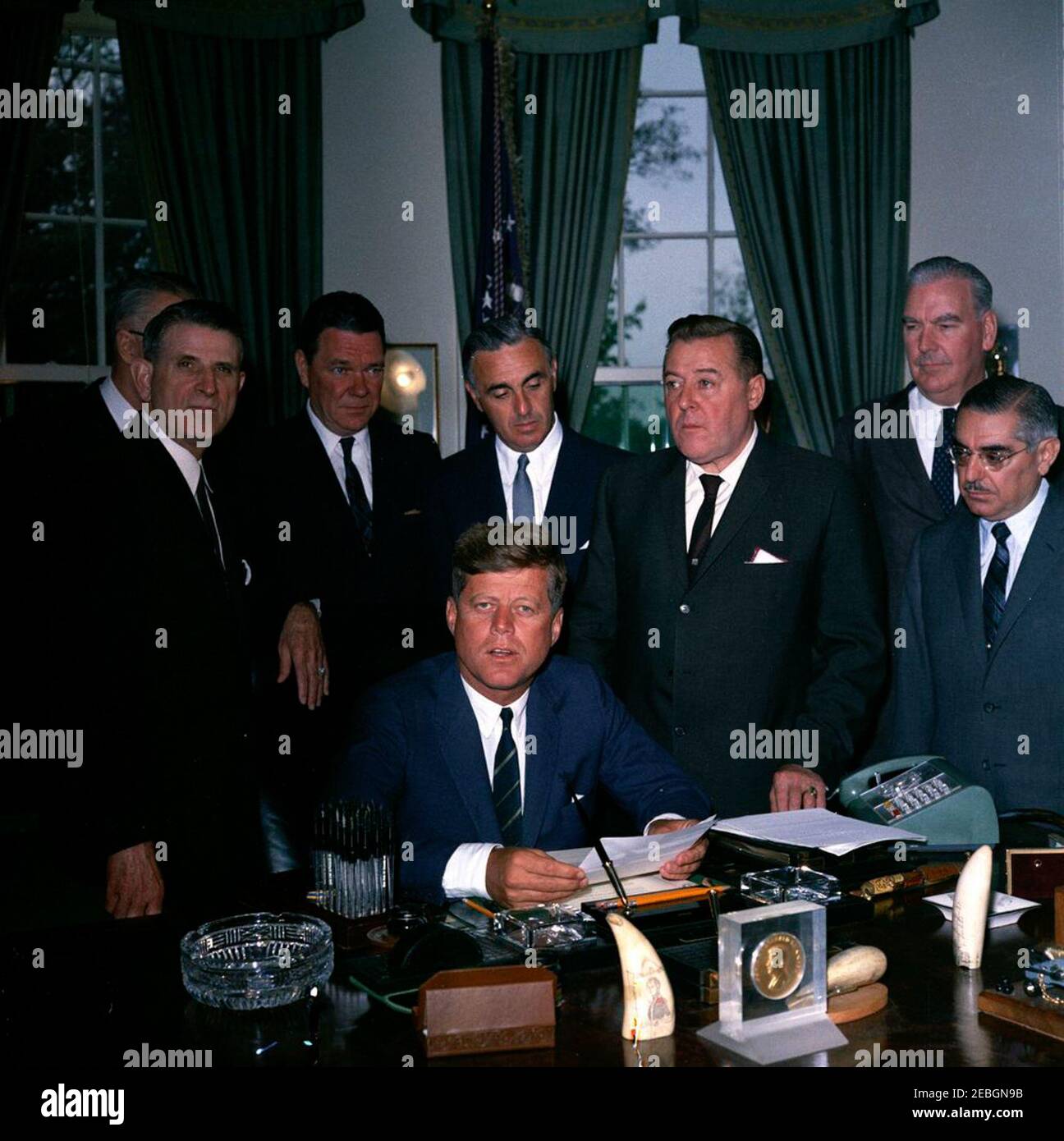 205 Legge pubblica 87-447, Legge sulla Televisione educativa, 12:00 PM. Il presidente John F. Kennedy (seduto) rilascia osservazioni dopo aver firmato la legge sulla televisione educativa. In piedi (L-R): Diversi uomini non identificati; senatore Clifford P. caso del New Jersey (in attesa di carta); senatore Norris Cotton del New Hampshire (in ombra); congressista Oren Harris (Arkansas); Segretario di Salute, Educazione e benessere, Abraham Ribicoff; avvocato, Leonard H. Marks (in retroscena); senatore Warren G. Magnuson (Washington); William L. Senatore John O. Pastore (Rhode Island). Ufficio ovale, Foto Stock