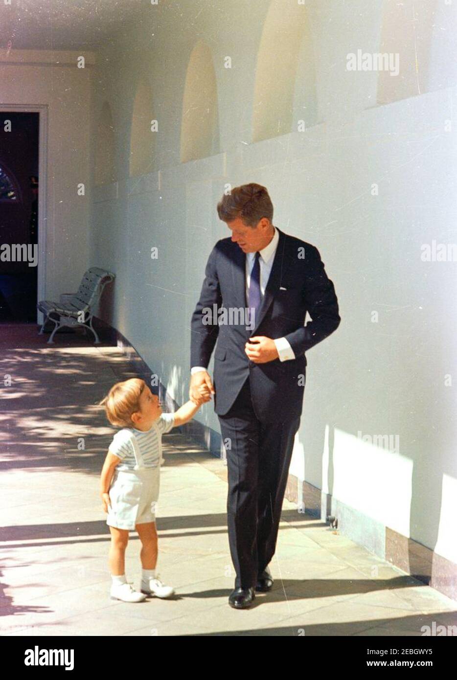 Il presidente Kennedy con John F. Kennedy Jr. (JFK, Jr.). Il presidente John F. Kennedy cammina con suo figlio, John F. Kennedy, Jr., lungo la West Wing Colonnade della Casa Bianca, Washington, D.C. Foto Stock