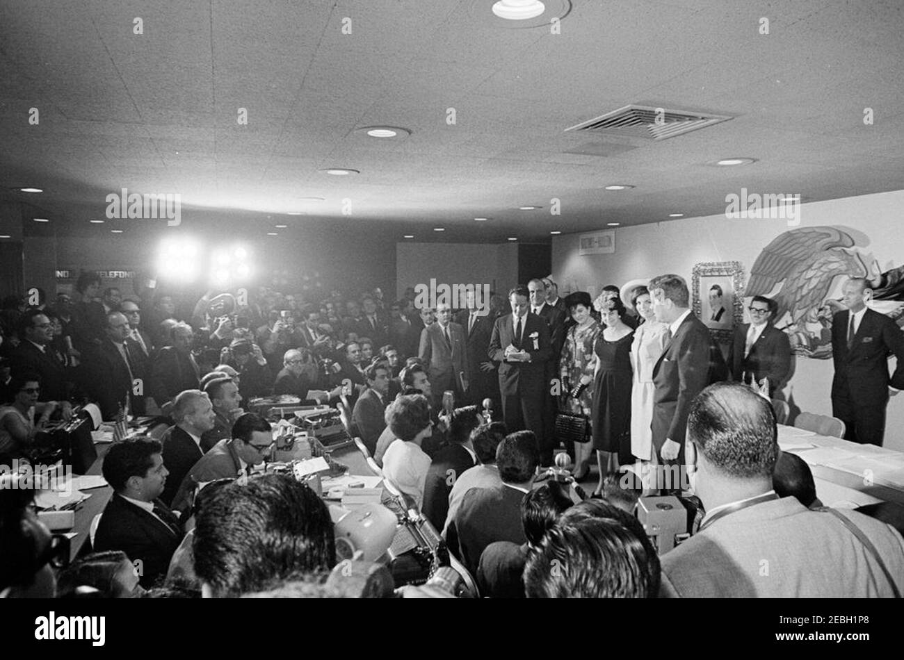 Viaggio in Messico: Pranzo in onore di Adolfo Lu00f3pez Mateos, presidente del Messico, 14:00 PM. Il presidente John F. Kennedy e la First Lady Jacqueline Kennedy si levano in piedi con il presidente del Messico, Adolfo Lu00f3pez Mateos, e la First Lady of Mexico, Eva Su00e1mano de Lu00f3pez Mateos, in una sala stampa presso l'Hotel Maru00eda Isabel. Anche nella foto: EVA Lu00f3pez Mateos; interprete del Dipartimento di Stato degli Stati Uniti, Donald Barnes; capo del protocollo degli Stati Uniti, Angier Biddle Duke; agente del Servizio Segreto della Casa Bianca, Jim Johnson. Città del Messico, Messico. Foto Stock
