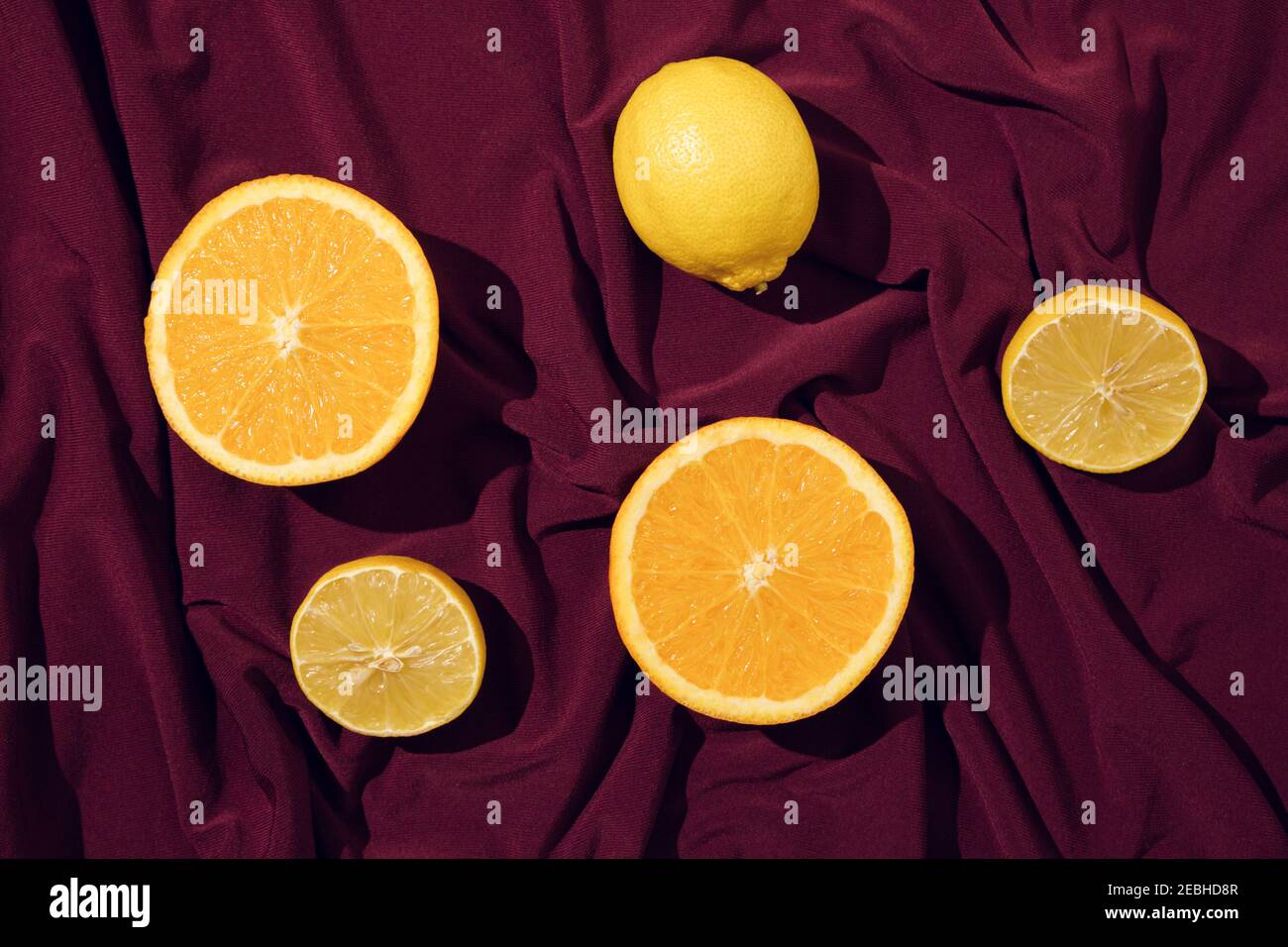 Limone su fondo di seta rossa o saten. Layout concettuale minimo. Foto Stock