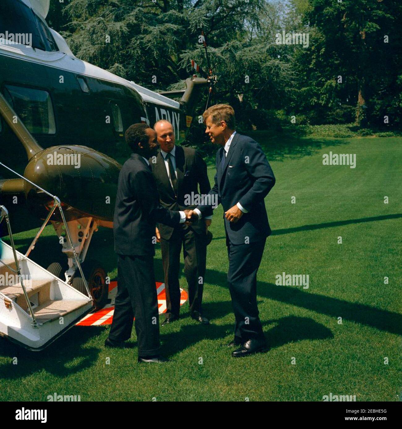 Cerimonia di arrivo per Julius Nyerere, presidente di Tanganyika, ore 11:30. Il presidente John F. Kennedy stringe le mani con il presidente del Tanganyika, Julius Nyerere, all'arrivo del presidente Nyerereu2019 alla Casa Bianca a bordo di un elicottero dell'esercito degli Stati Uniti. Il capo DEL protocollo DEGLI STATI UNITI, Angier Biddle Duke, si trova al centro. South Lawn, Casa Bianca, Washington, D.C. Foto Stock