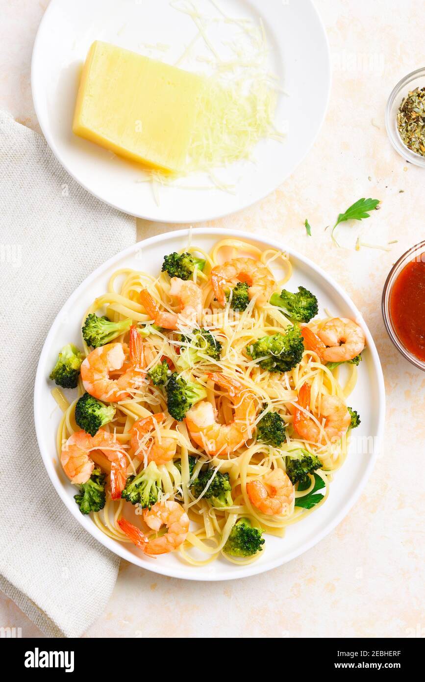 Gamberi e broccoli su piastra su fondo di pietra leggera. Piatto gustoso per cena. Vista dall'alto, piatto Foto Stock