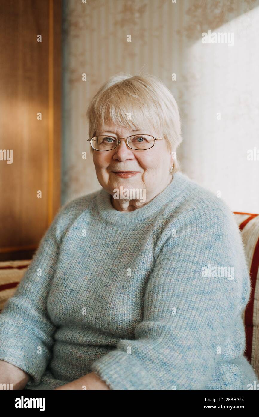 Primo piano candido, ritratto autentico di donna bionda senior Plus size a casa. Ritratto di donna matura con occhiali Foto Stock