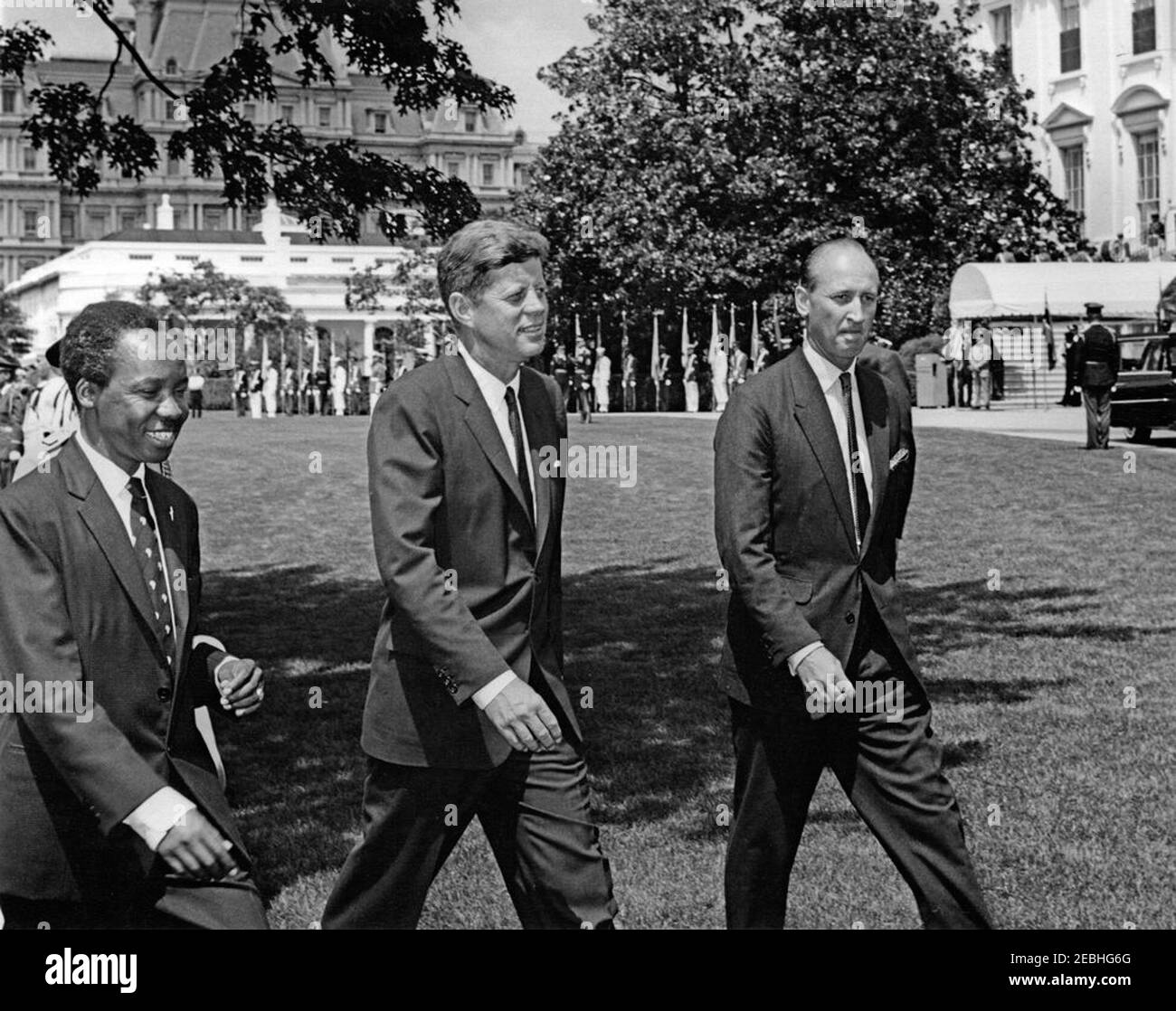 Cerimonia di arrivo per Julius Nyerere, presidente di Tanganyika, ore 11:30. Il presidente John F. Kennedy cammina con il presidente del Tanganyika, Julius K. Nyerere (a sinistra), dopo le cerimonie di arrivo in onore del presidente Nyerere. IL capo DEL protocollo DEGLI STATI UNITI, Angier Biddle Duke, cammina a destra. South Lawn, Casa Bianca, Washington, D.C. Foto Stock