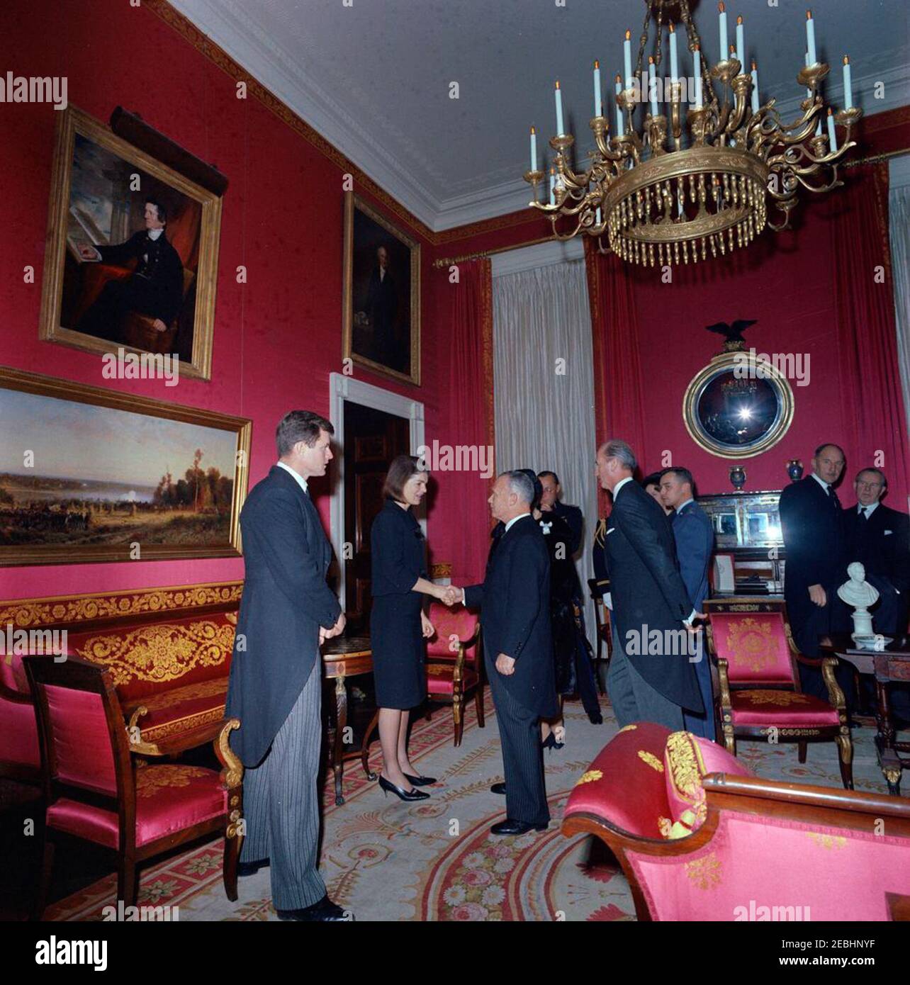 Funerali di Stato del presidente Kennedy: White House, ricezione funeraria post. Jacqueline Kennedy e il senatore Edward M. Kennedy (Massachusetts) accolgono gli ospiti durante un ricevimento alla Casa Bianca, dopo i funerali di stato del presidente John F. Kennedy; la Sig.ra Kennedy scuote le mani con il ministro degli Affari Esteri della Grecia, Sophocles Venizelos. Anche nella foto: Il Principe Bernardo dei Paesi Bassi; la Principessa Beatrice dei Paesi Bassi (per lo più nascosta); il Ministro degli Affari Esteri dei Paesi Bassi, Joseph Luns; il primo Ministro del Canada, Lester B. Pearson; il Capo del protocollo degli Stati Uniti, Angier Biddle Duke. Rosso Roo Foto Stock