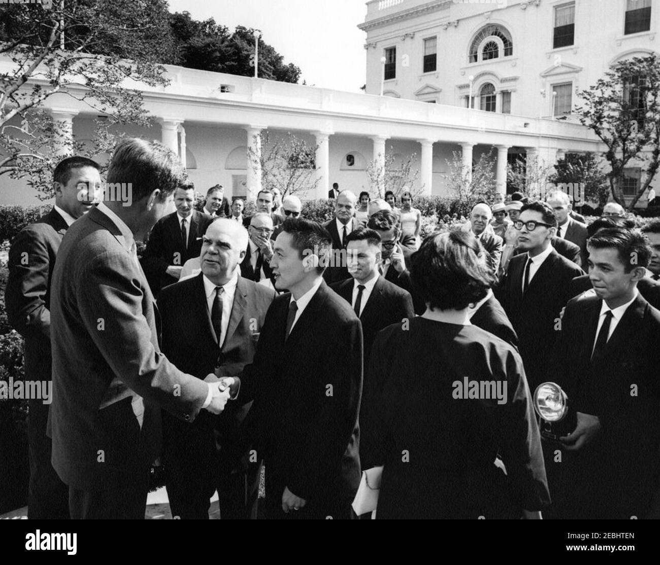 Visita di Eskimo u0026 Alaska studenti di elettronica indiana, 9:55. Il presidente John F. Kennedy stringe le mani con Morgan Aukongak, un tirocinante dell'elettronica dell'Alaska, durante una visita con un gruppo di tirocinanti dell'elettronica indiana di Eskimo e dell'Alaska nel Rose Garden della Casa Bianca, Washington, D.C. in primo piano (L-R): Segretario dell'interno, Stewart L. Udall; Presidente Kennedy; Commissario del Bureau of Indian Affairs nel Dipartimento dell'interno, Philleo Nash; MR. Aukongak; tirocinanti, Joseph Pungowiyi, Russell W. Attwood (parzialmente nascosto), non identificato (di nuovo alla macchina fotografica), Percy Ipal Foto Stock