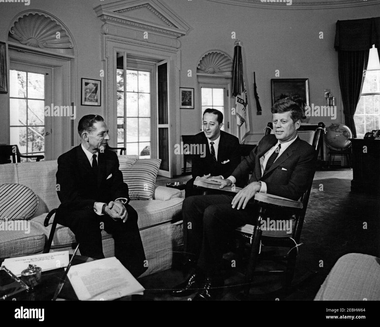 Incontro con l'Ambasciatore della Colombia, Dott. Eduardo Uribe Botero, 11:37. Il presidente John F. Kennedy (a destra, in sedia a dondolo) incontra il neo nominato ambasciatore della Colombia, il dottor Eduardo Uribe Botero; l'interprete del Dipartimento di Stato degli Stati Uniti, Donald Barnes, si trova al centro. Ufficio ovale, Casa Bianca, Washington, D.C. Foto Stock