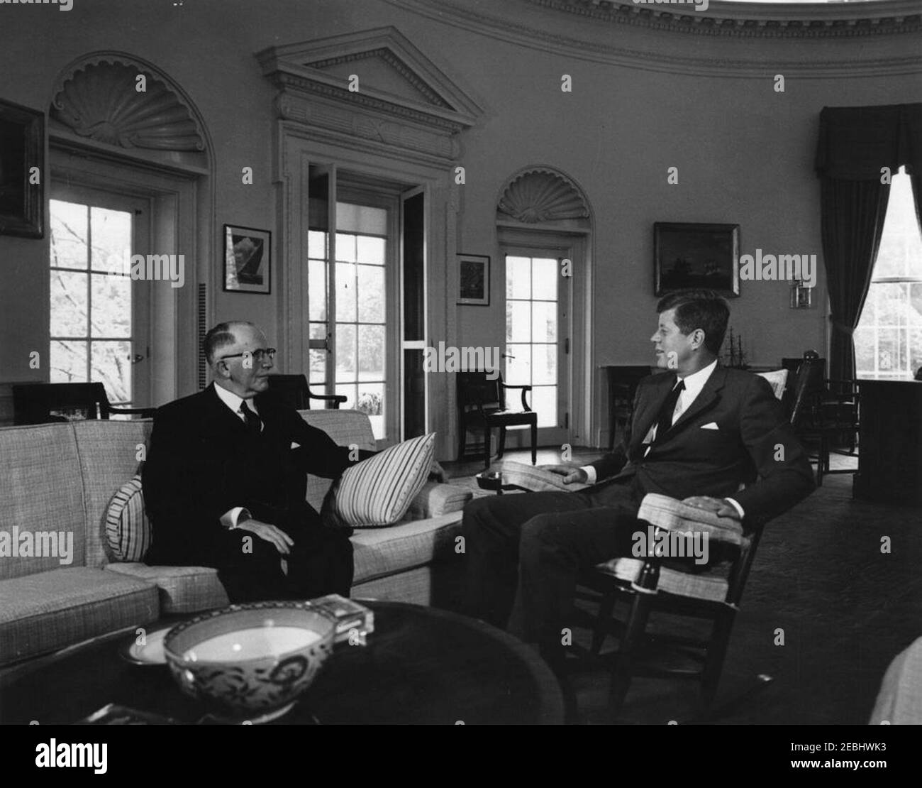 Incontro con H. Ladd Plumley, presidente della Camera di Commercio degli Stati Uniti, alle 10:37. Il presidente John F. Kennedy (in sedia a dondolo) incontra il presidente della Camera di Commercio degli Stati Uniti, H. Ladd Plumley. Ufficio ovale, Casa Bianca, Washington, D.C. Foto Stock